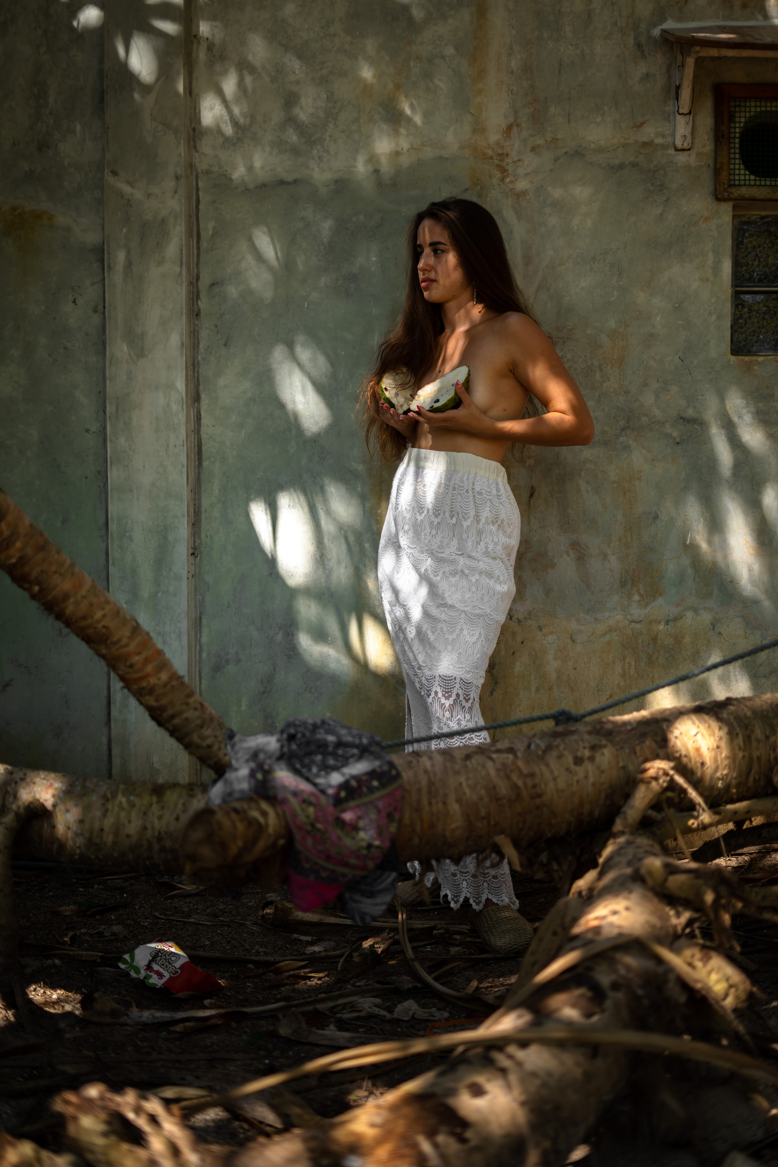 a partially nude girl with watermelons against a bright summer backdrop