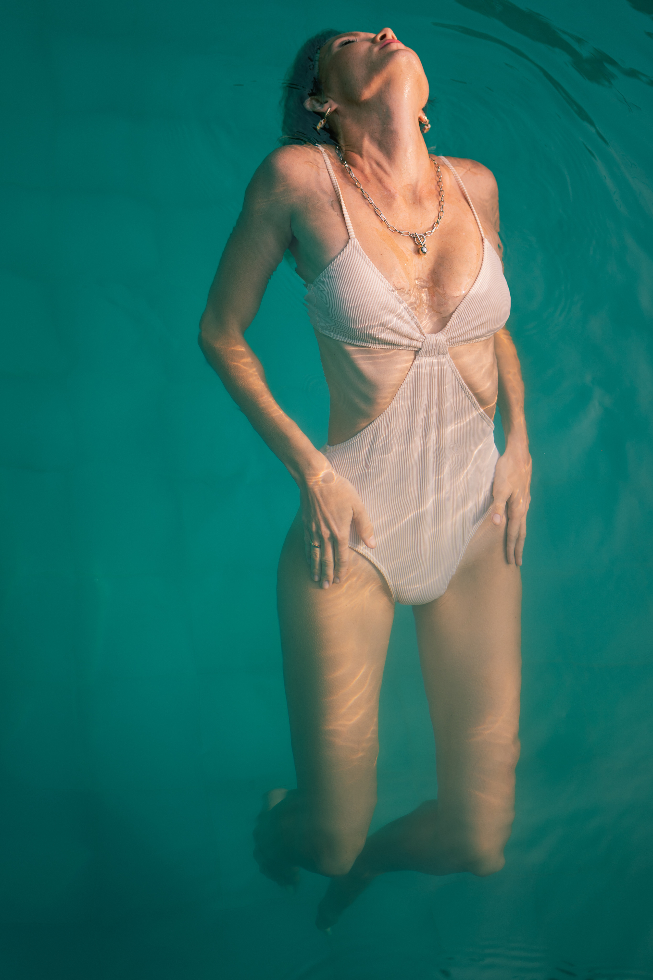 a girl in a white swimsuit enjoying her time by the water