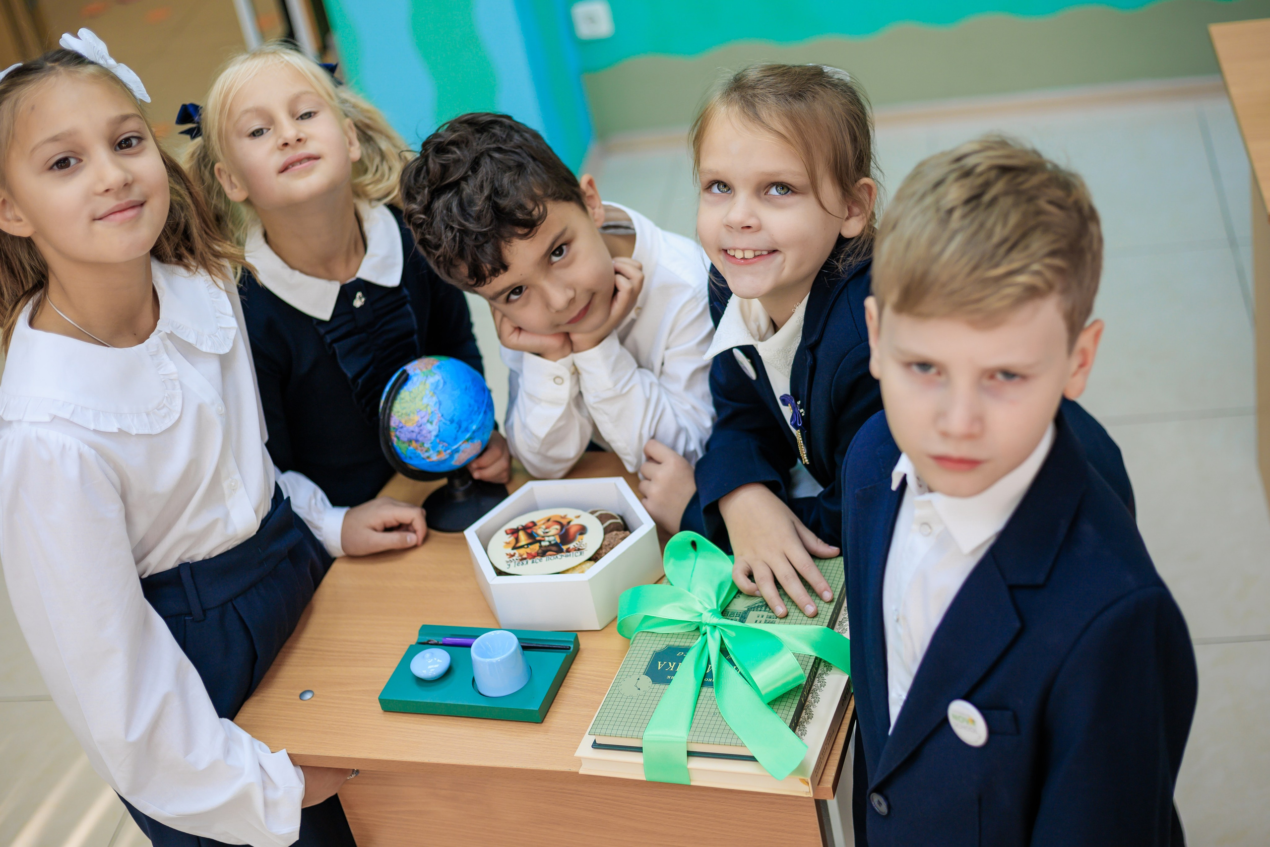 ученики собрались вокруг торта и смотрят в камеру