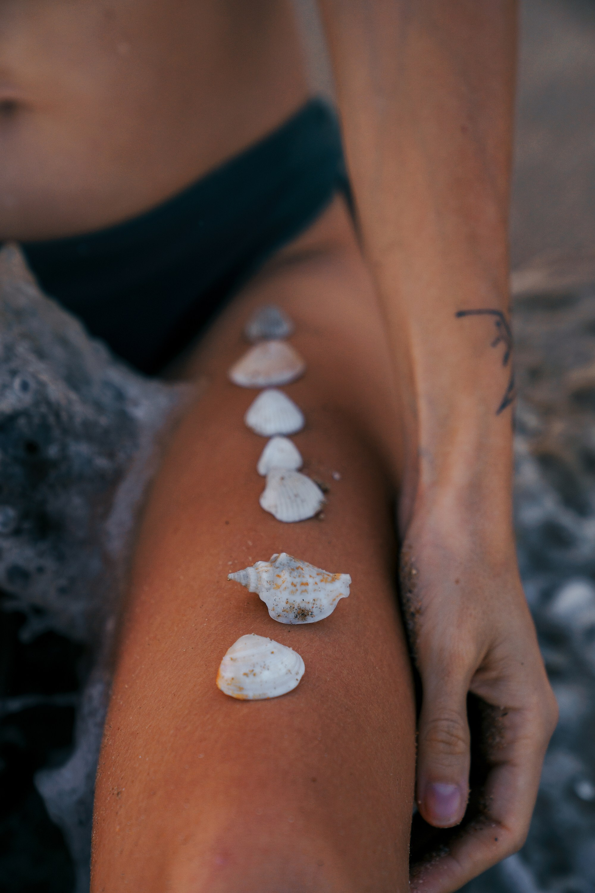 Крупный план морских ракушек на загорелой коже девушки, эстетика пляжной фотосессии на море Kartashow