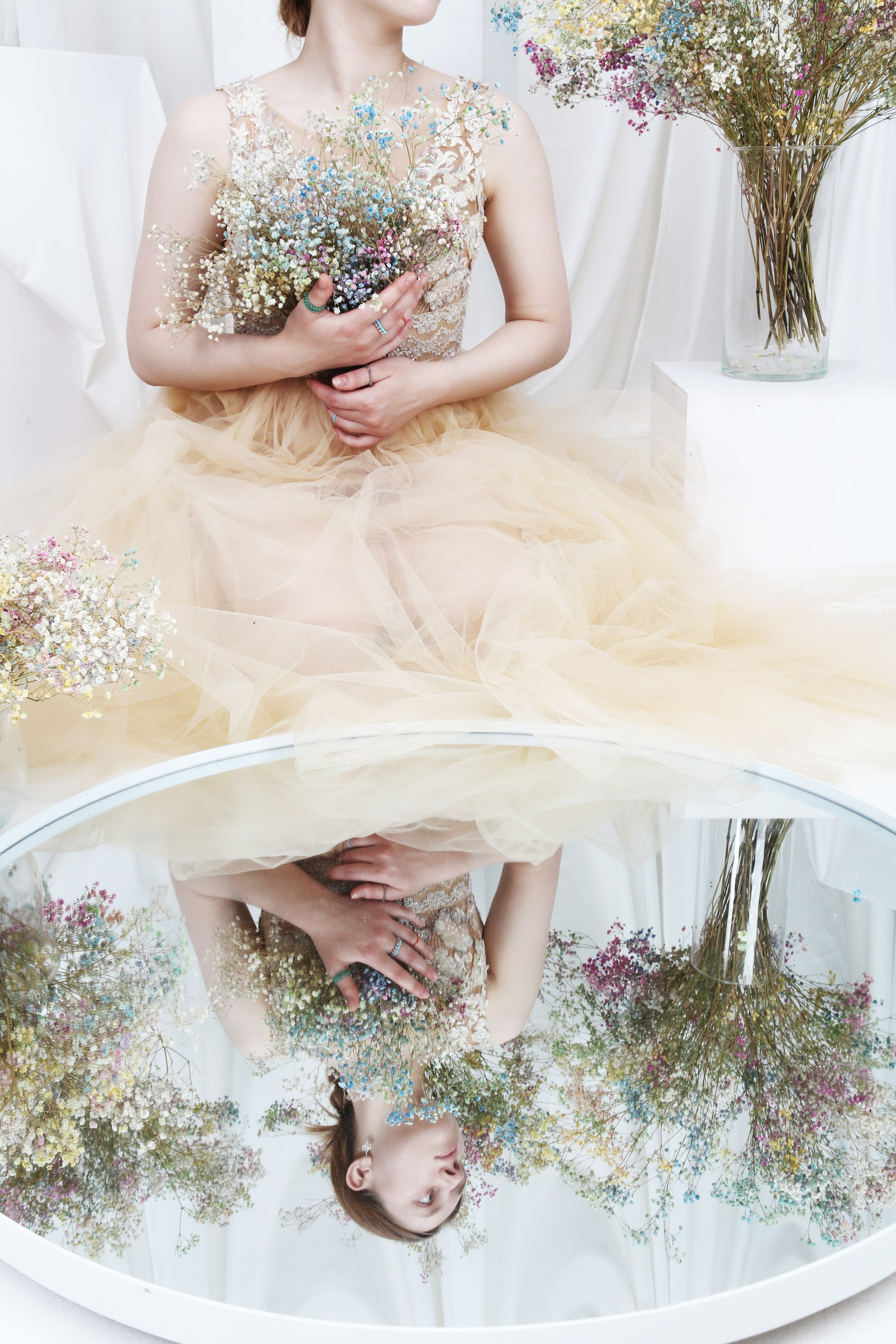 Девушка отражается в зеркале с цветами с платьем