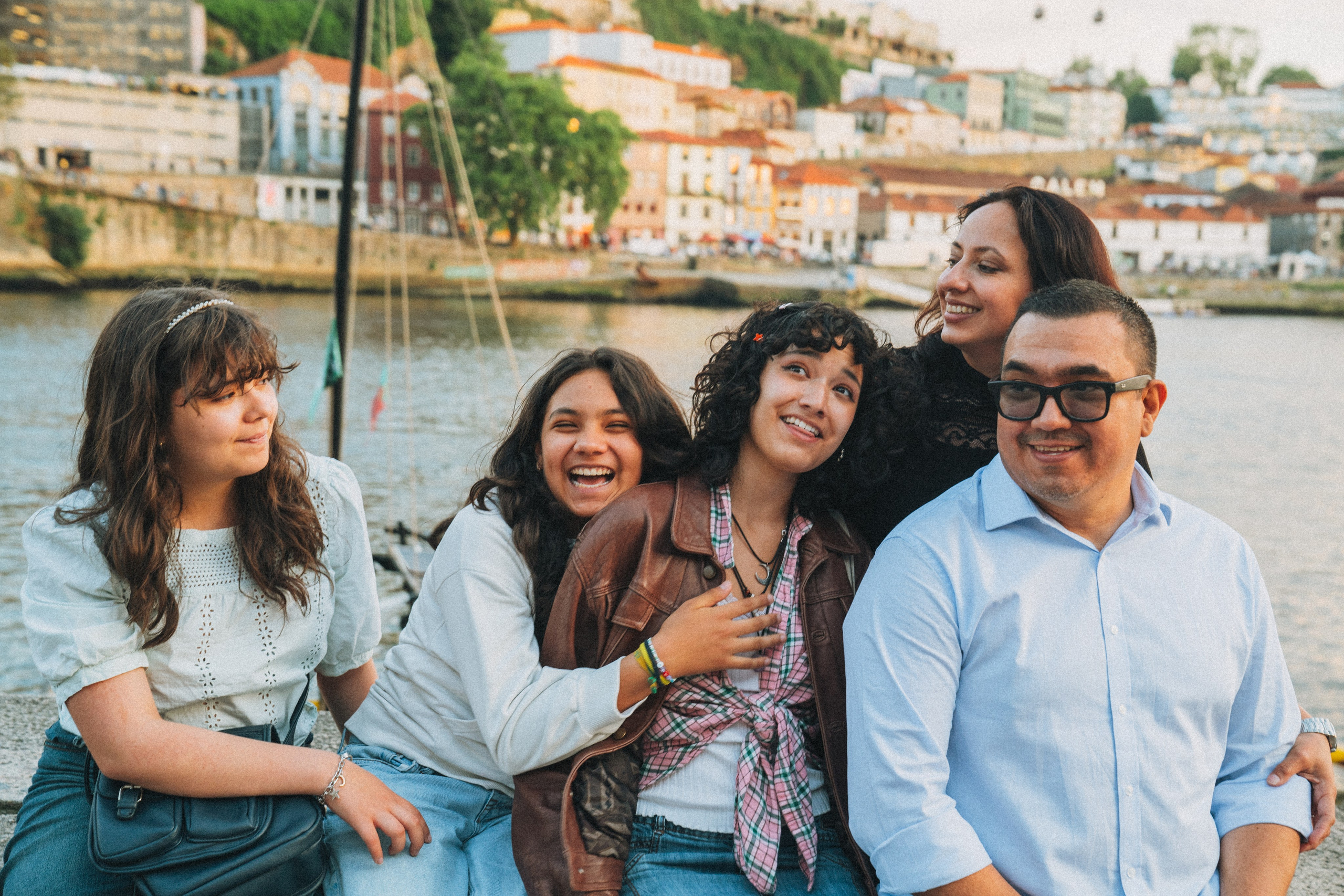 Группа людей семья влюбленные гуляет по живописной узкой улочке в Португалии, окружённой старыми домами и зеленью.