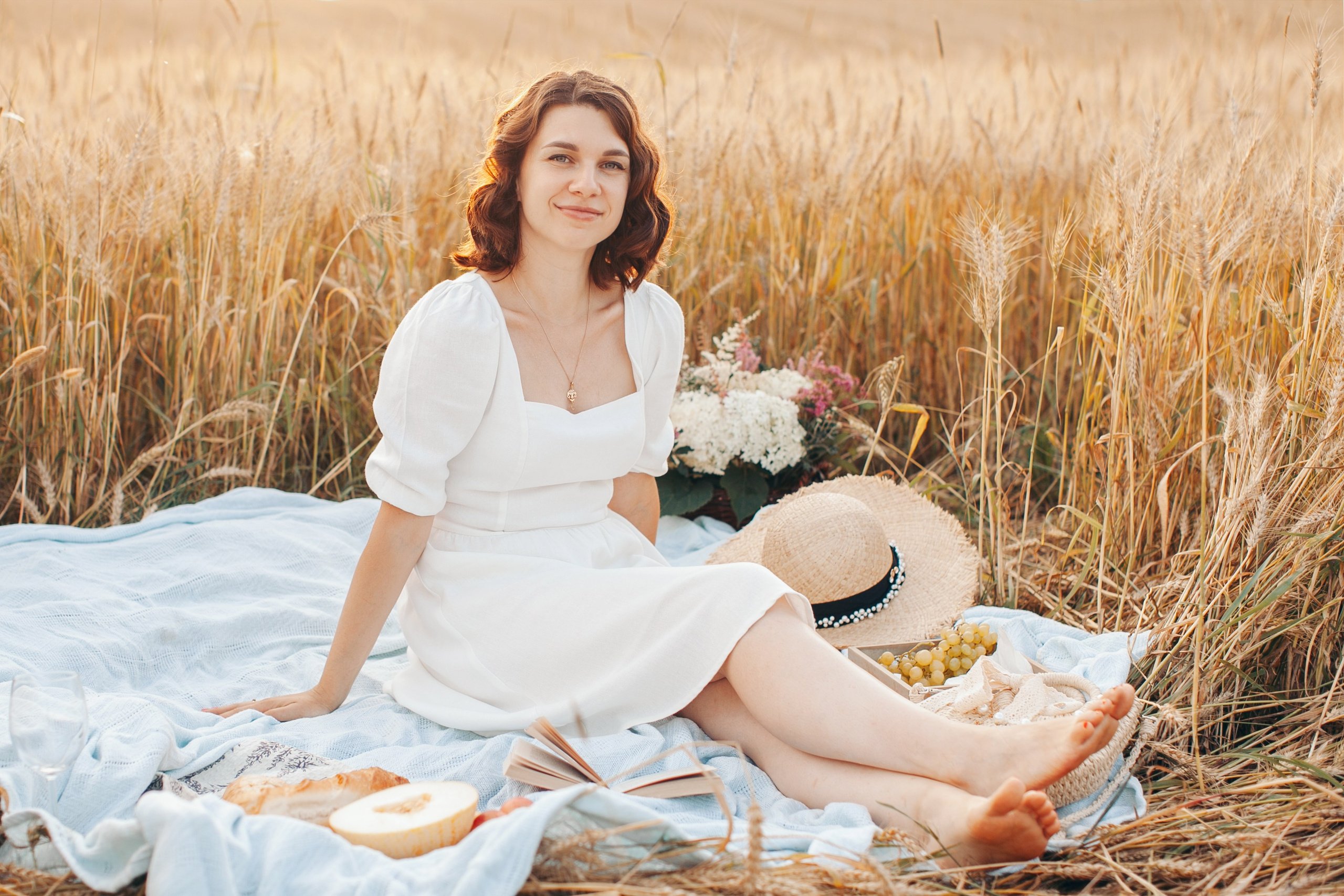 Красивая девушка позирует на поле в закатное время 