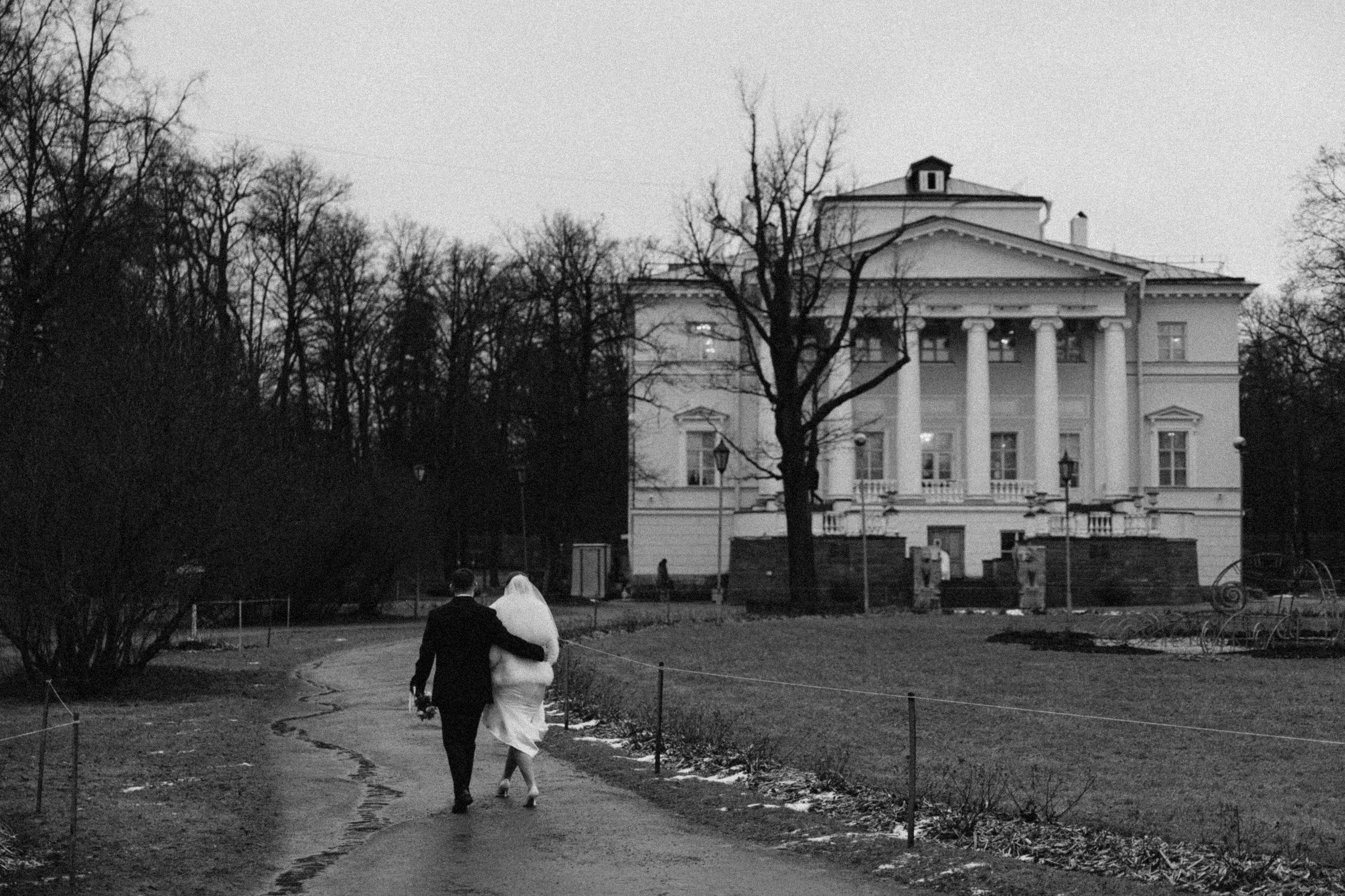 Черно-белое фото: жених и невеста идут в Пушкинский ЗАГС, в пасмурный день. Атмосферная свадебная прогулка.