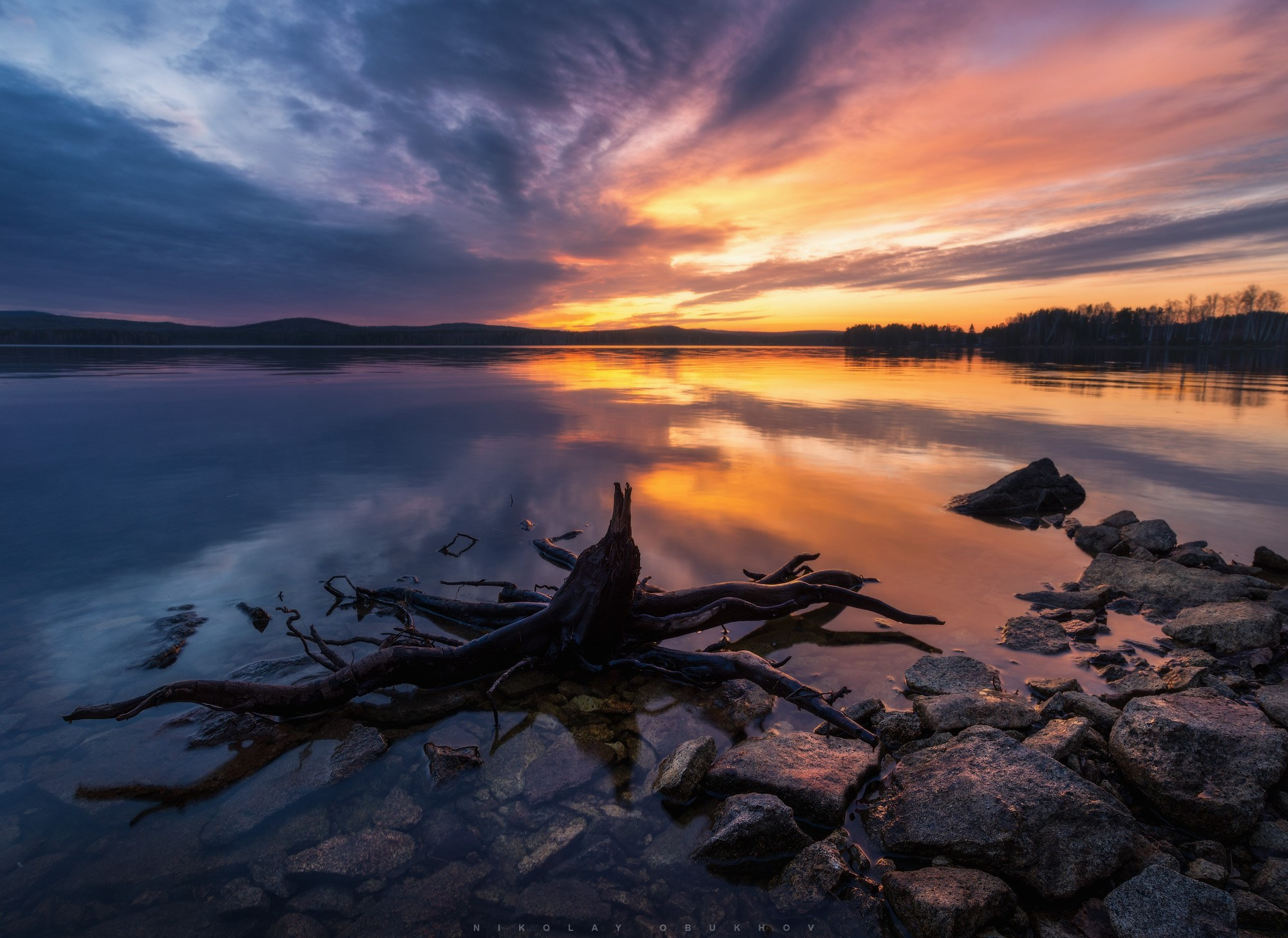 Фотографии природы на берегу Черноисточинского пруда — тихая гладь воды отражает закатное небо.
