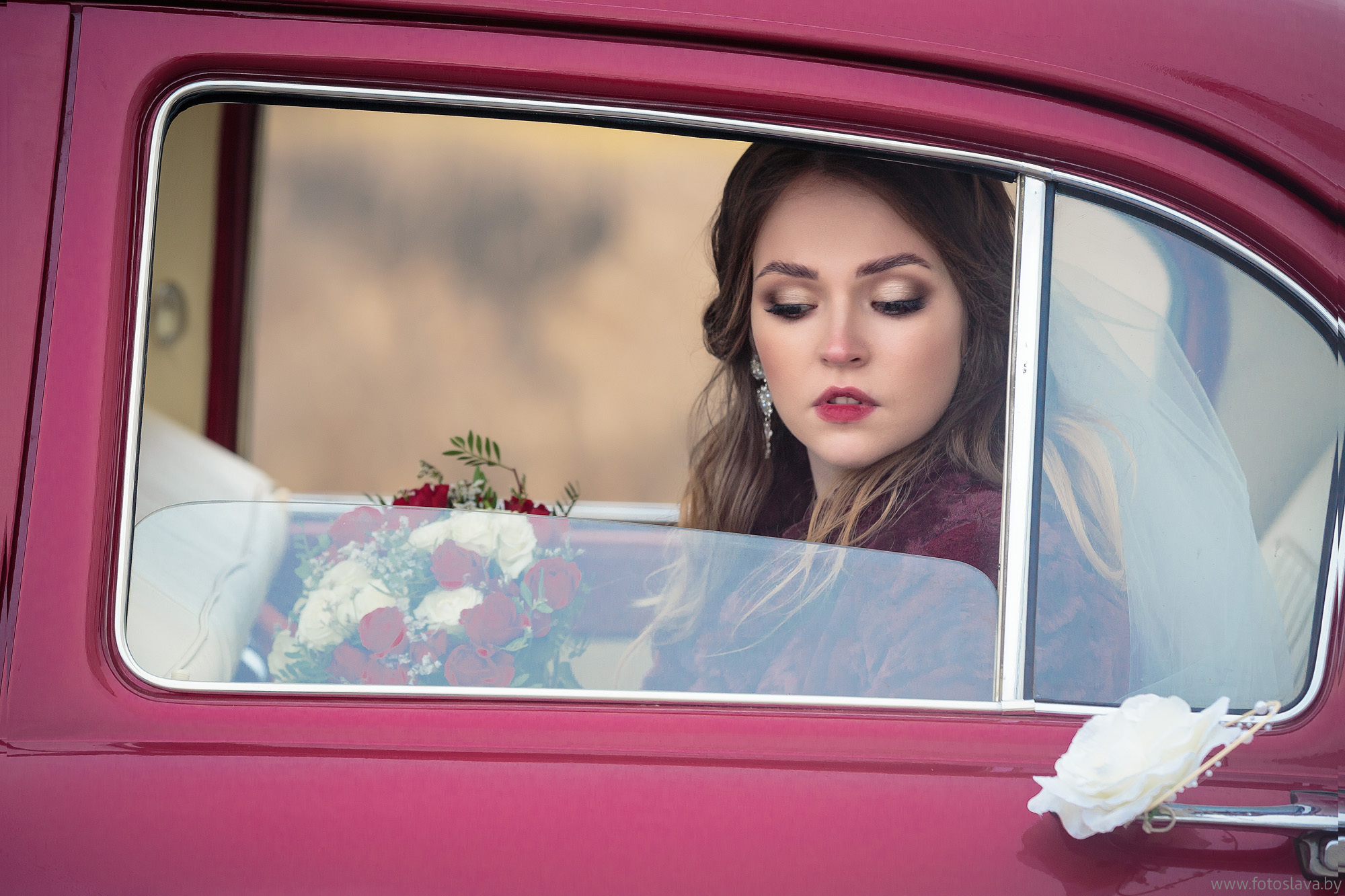 задумчивый портрет невесты в окне автомобиля.