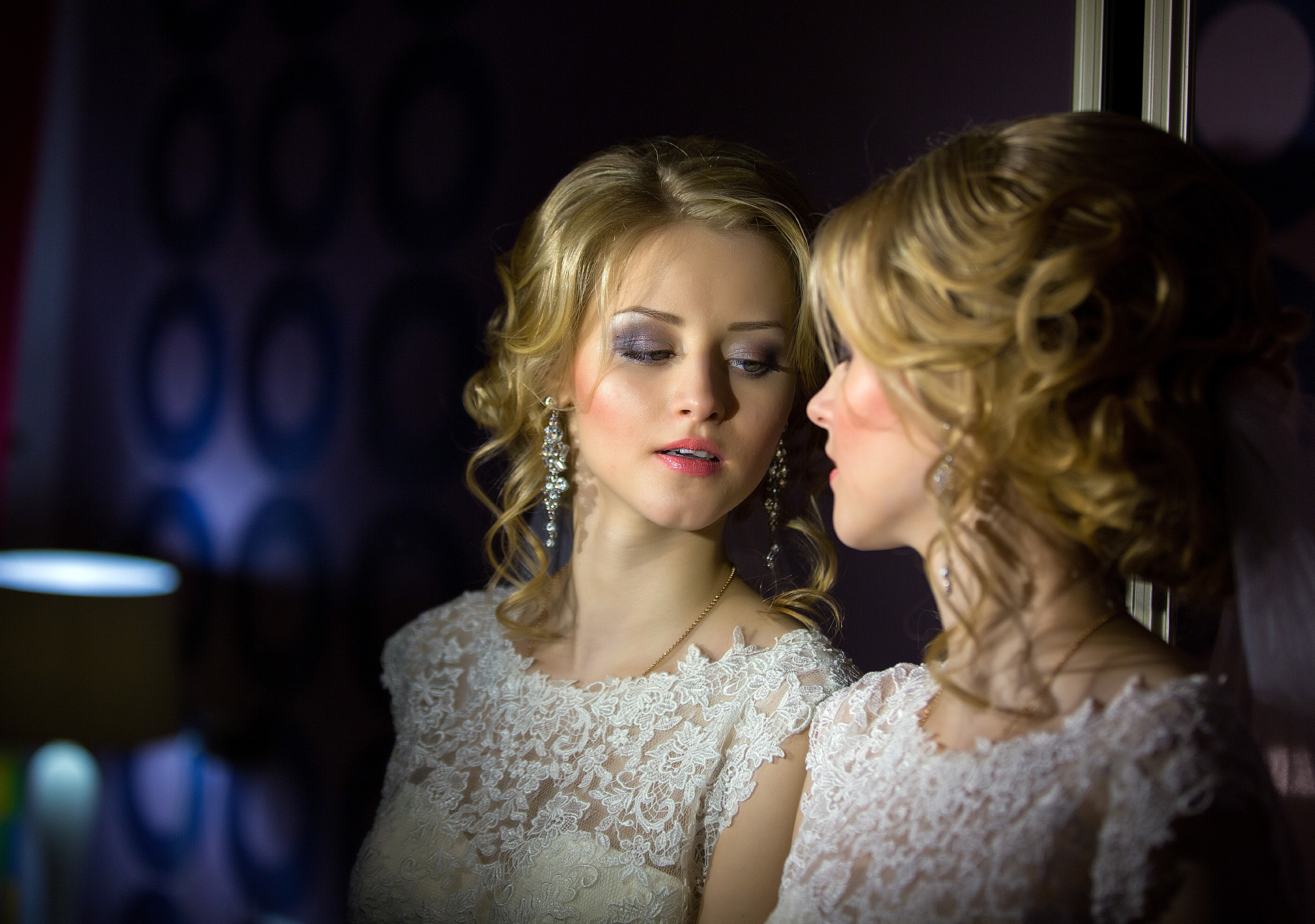 невеста смотрит на себя в зеркало.