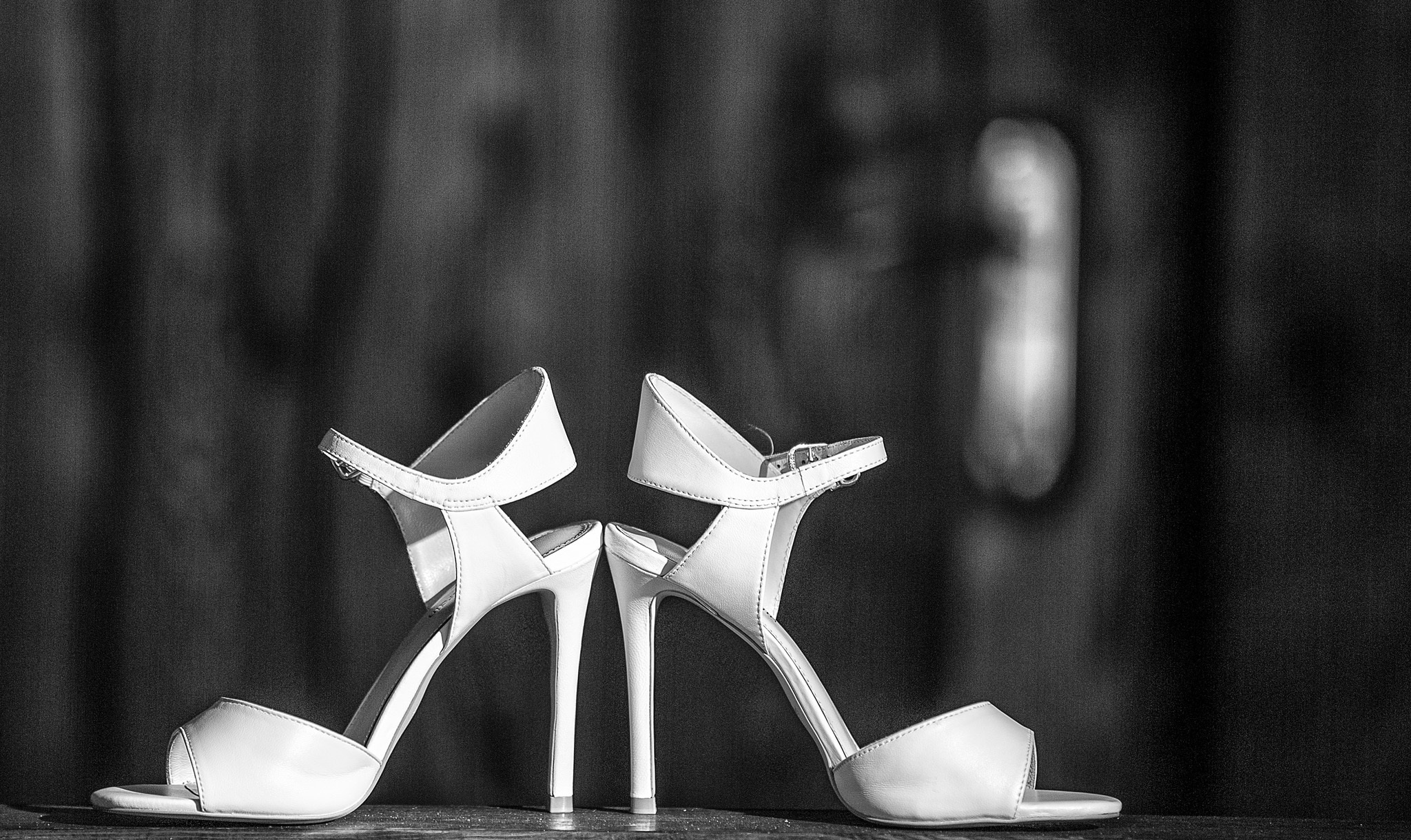белые туфли невесты на размытом темном фоне.