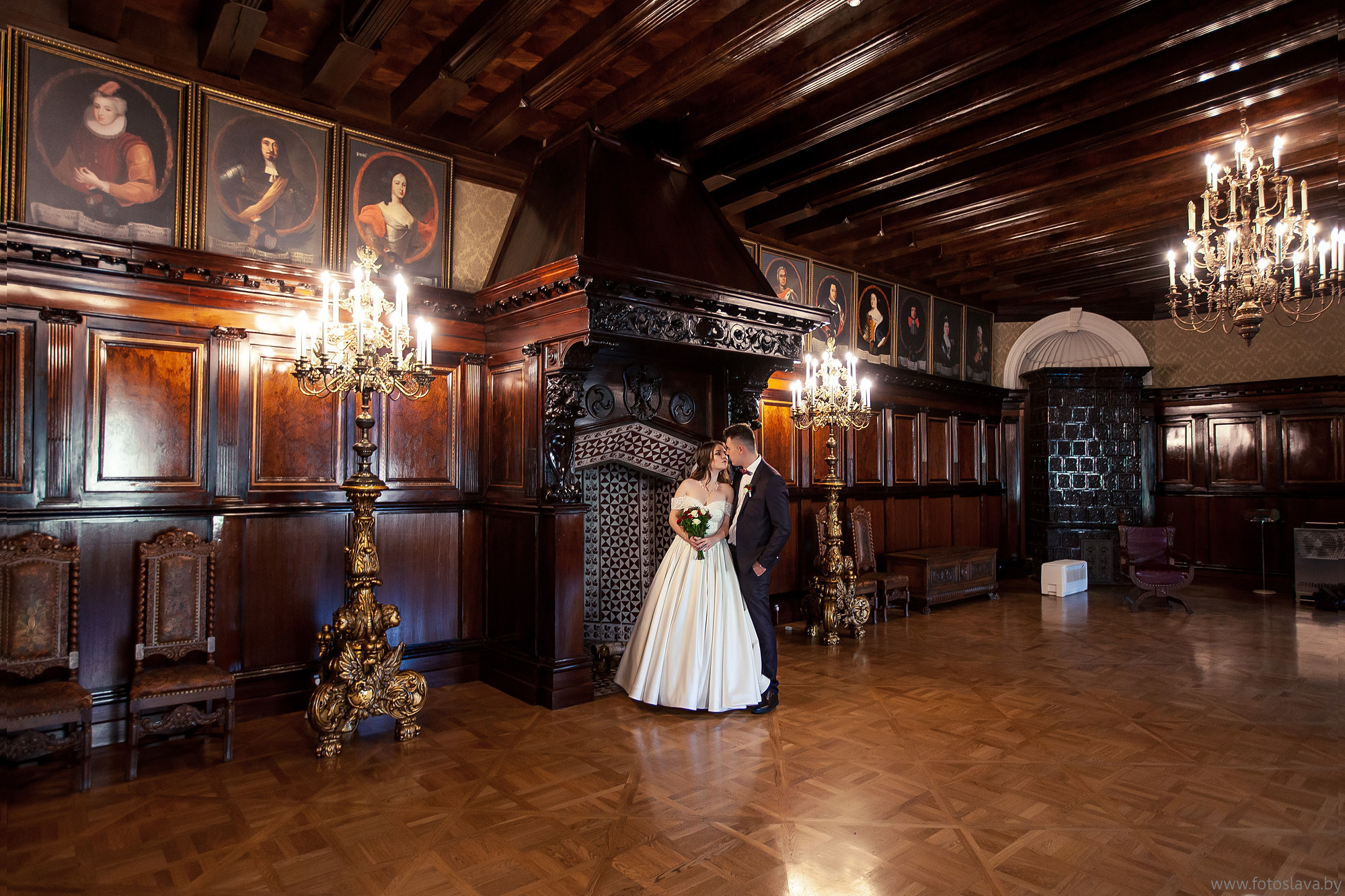 невеста с женихом целуются в каминном зале несвижского замка.