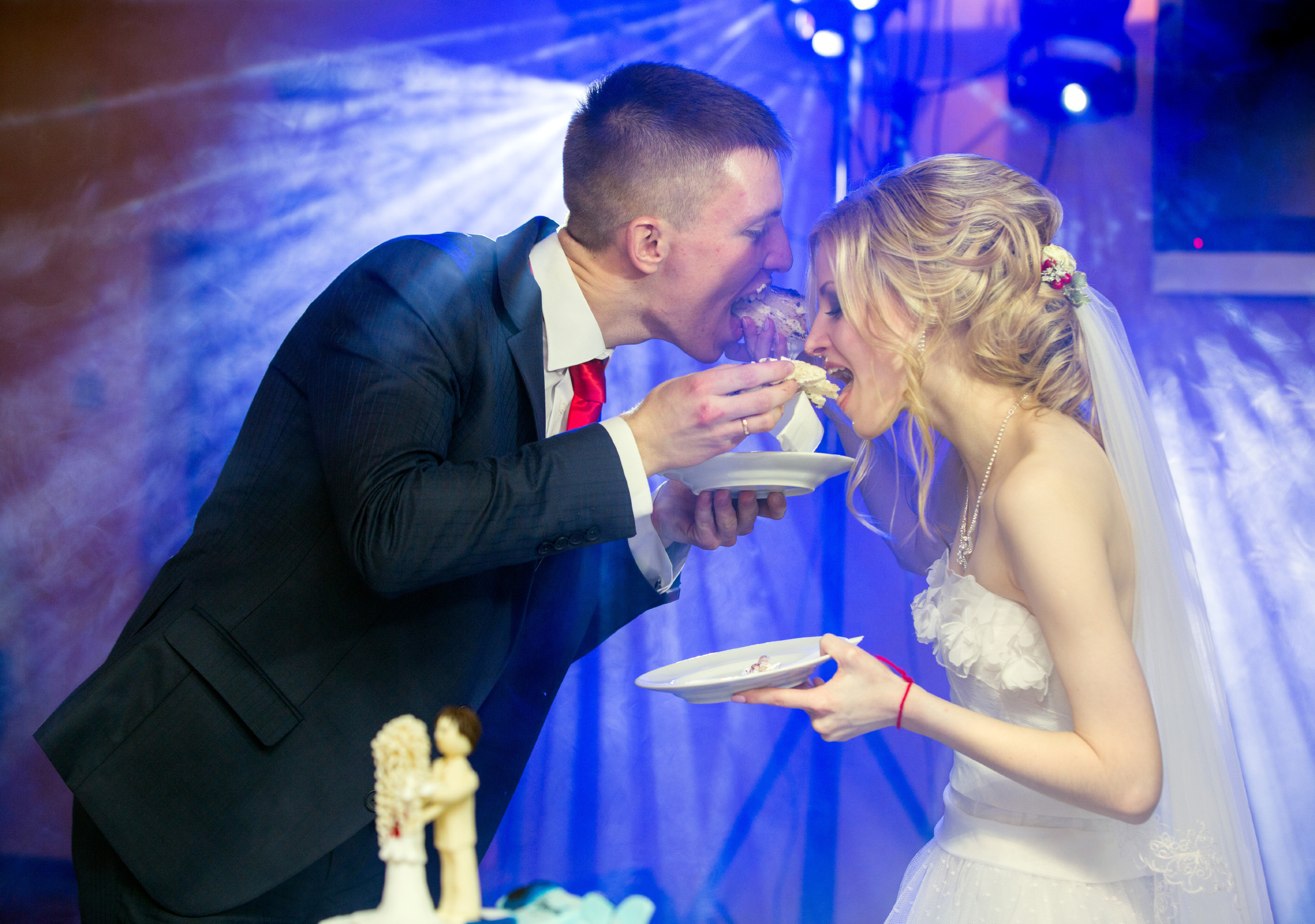 жених с невестой угощают друг друга тортом.
