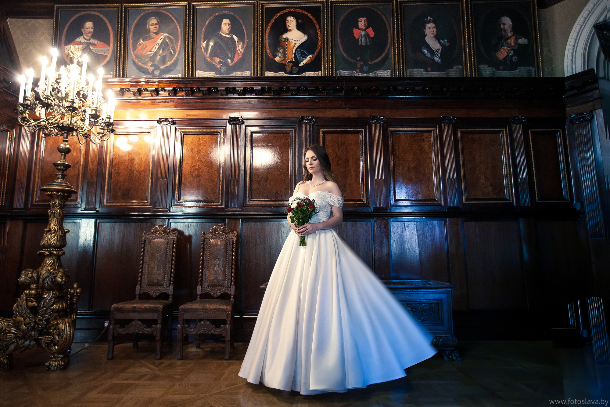 невеста с букетом одна в полный рост в темном зале замка в Несвиже.