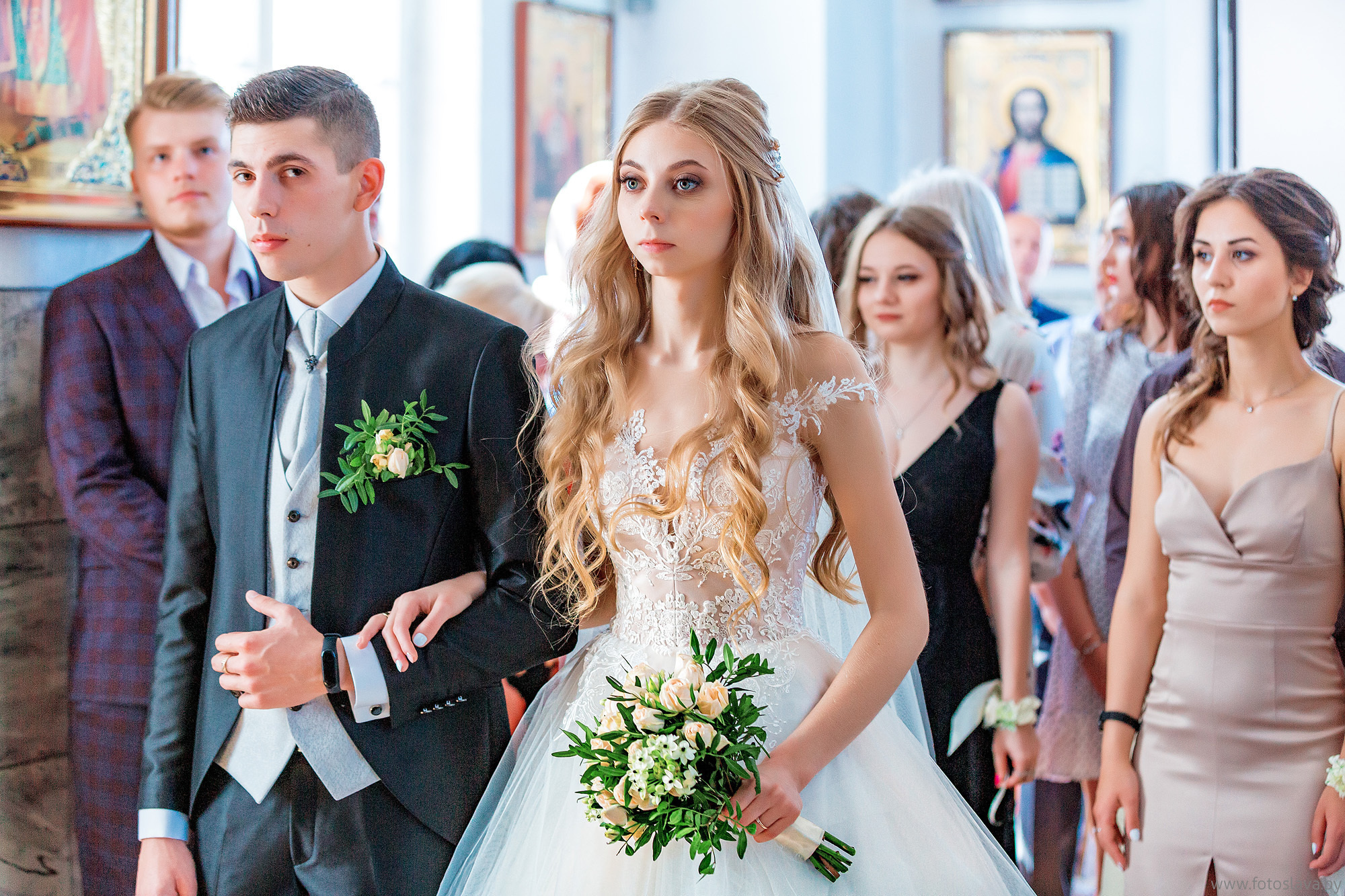 молодожены  по пояс на фоне гостей в соборе.
