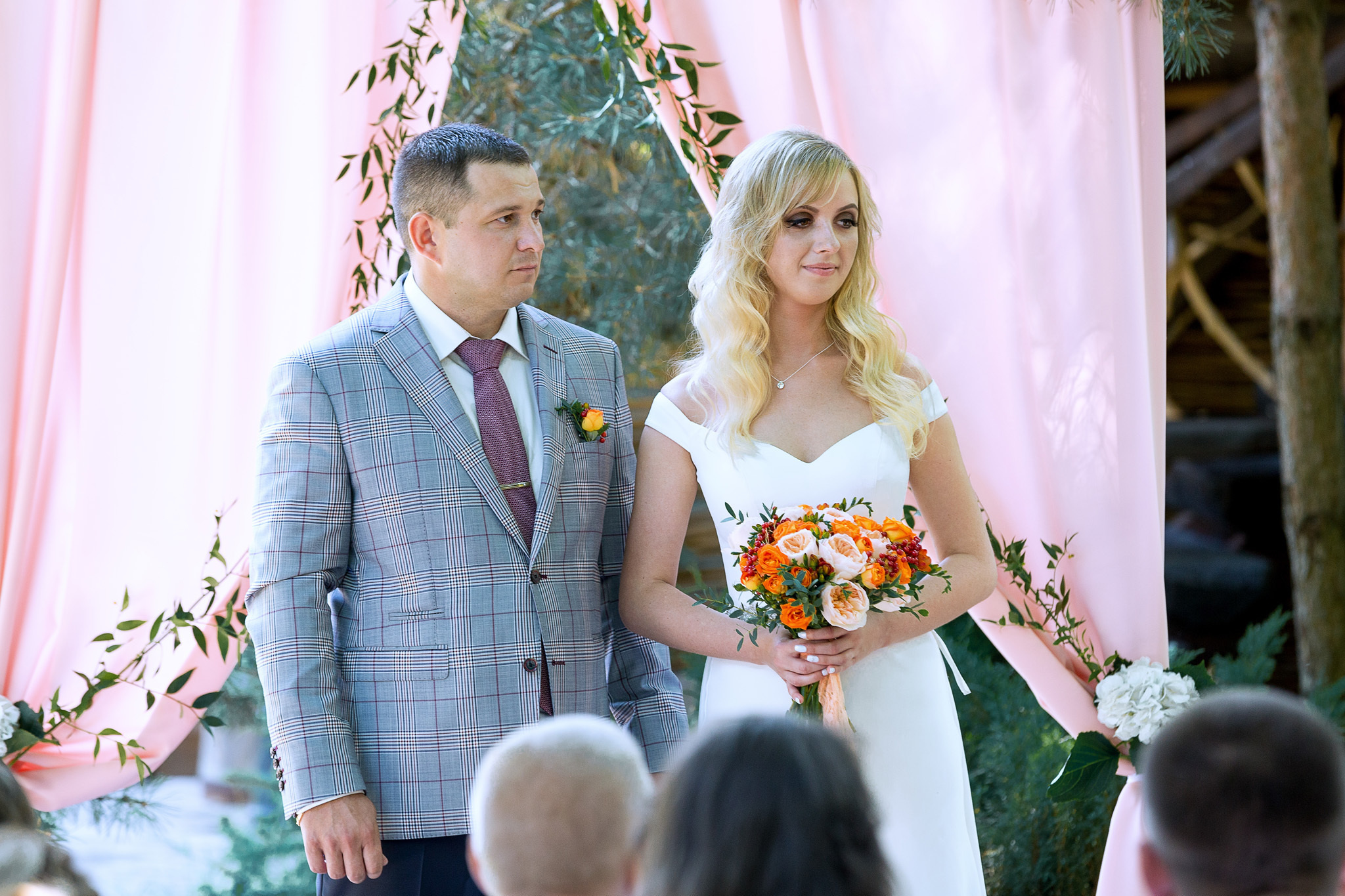 выездная регистрация, молодожены стоят рядом под аркой.