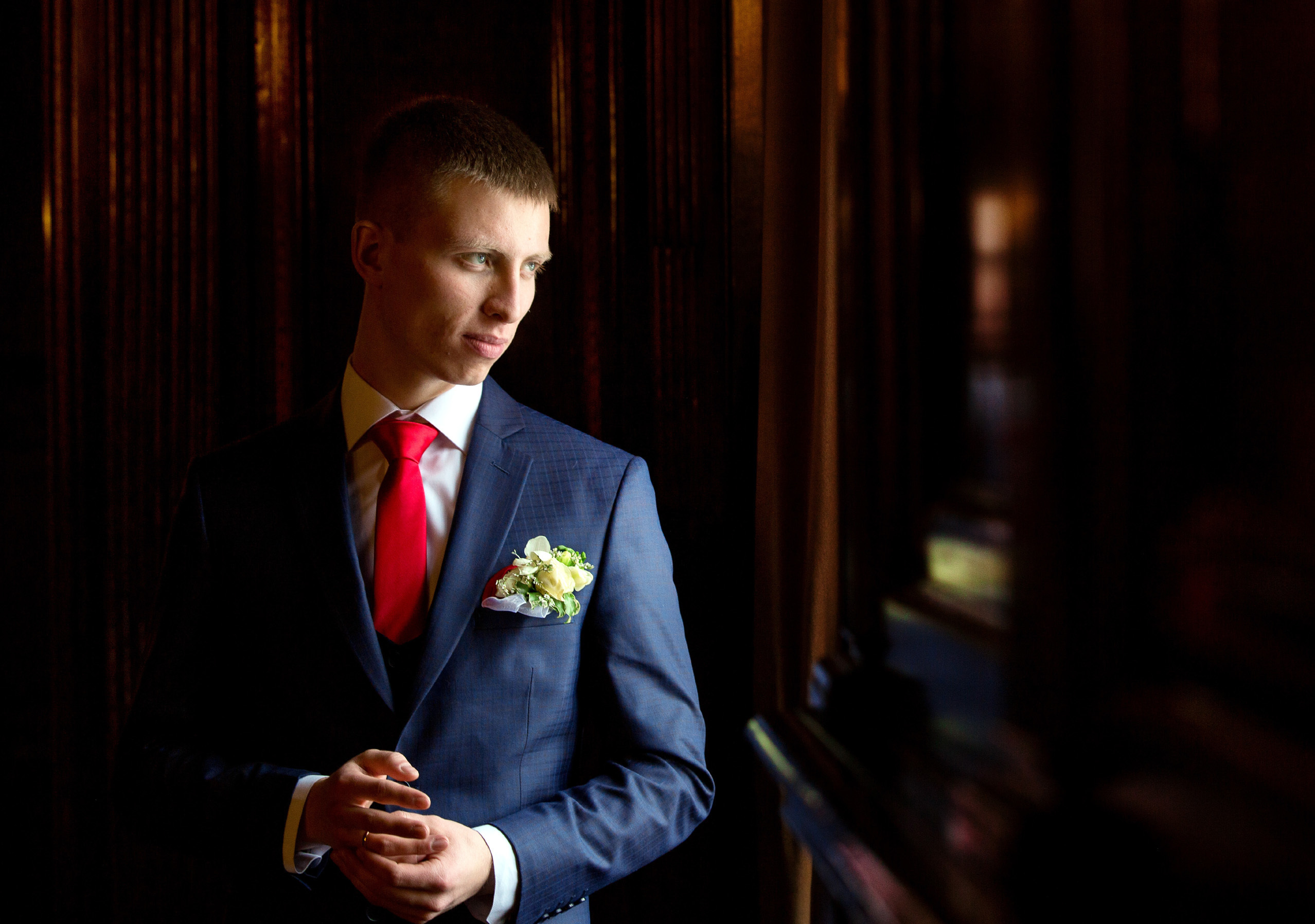 портрет жениха на темном фоне со светом от окна. 