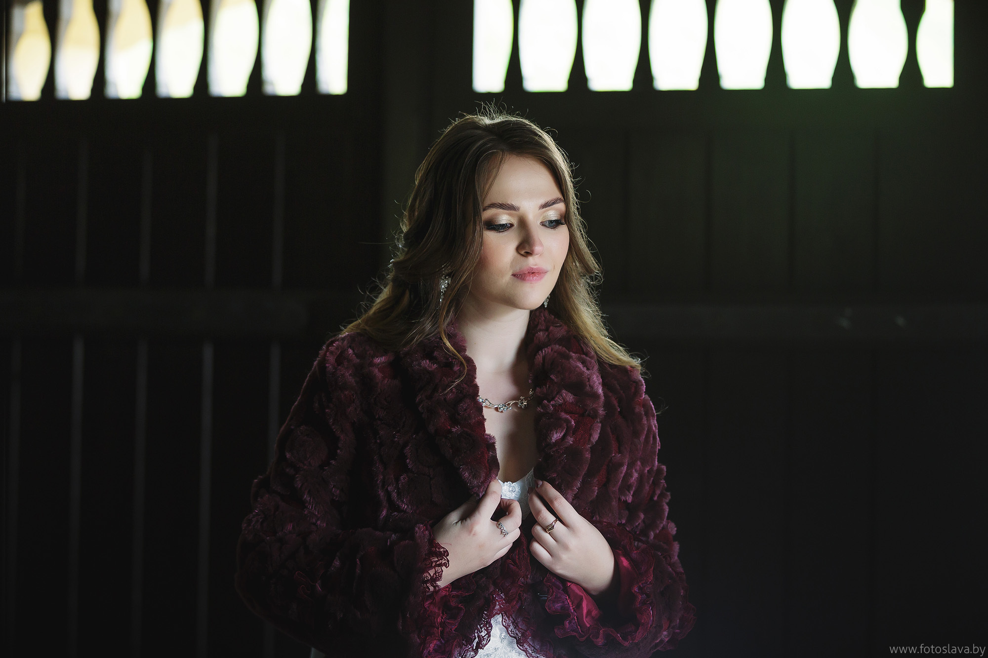портрет невесты по пояс на фоне темных дверей.