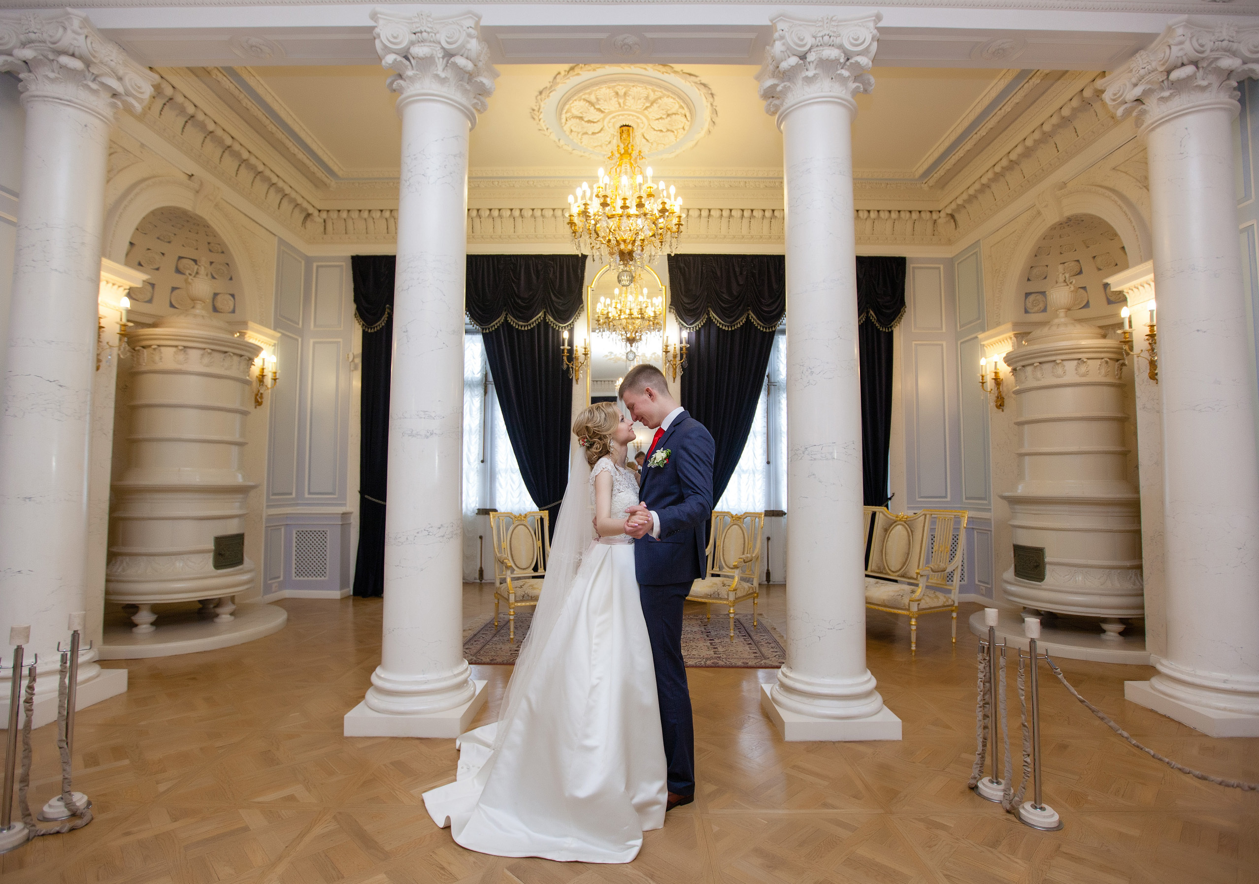 невеста с женихом танцуют в зале замка.