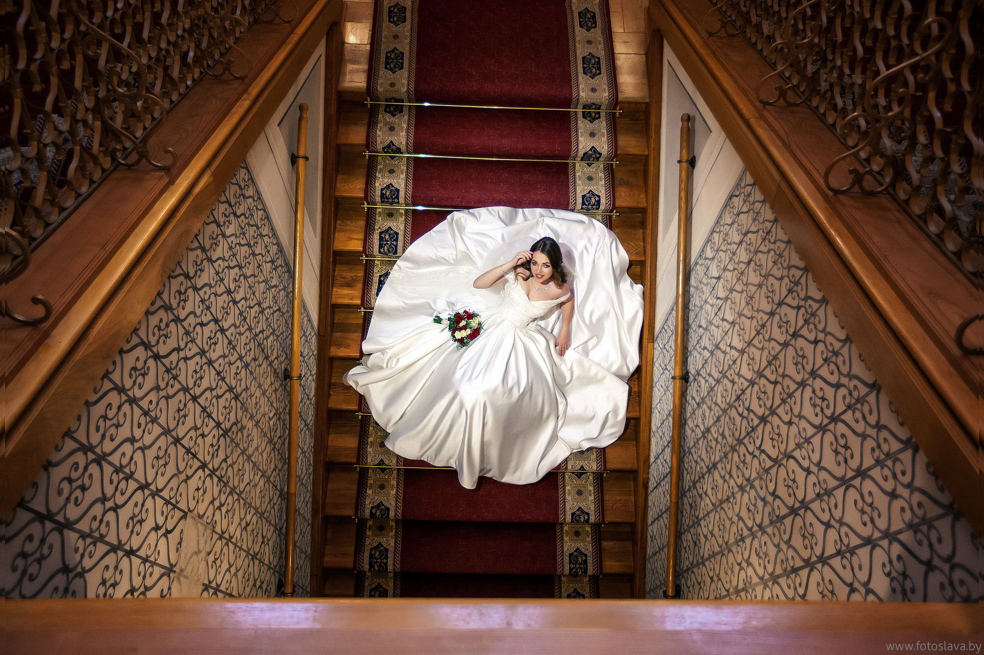 невеста сидит на лестнице в замке, вид сверху.
