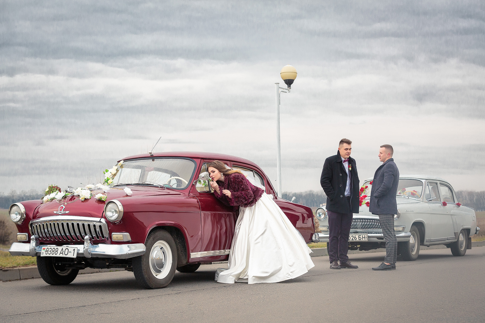 невеста смотрит в зеркало ретроавто, на фоне жених с другом.