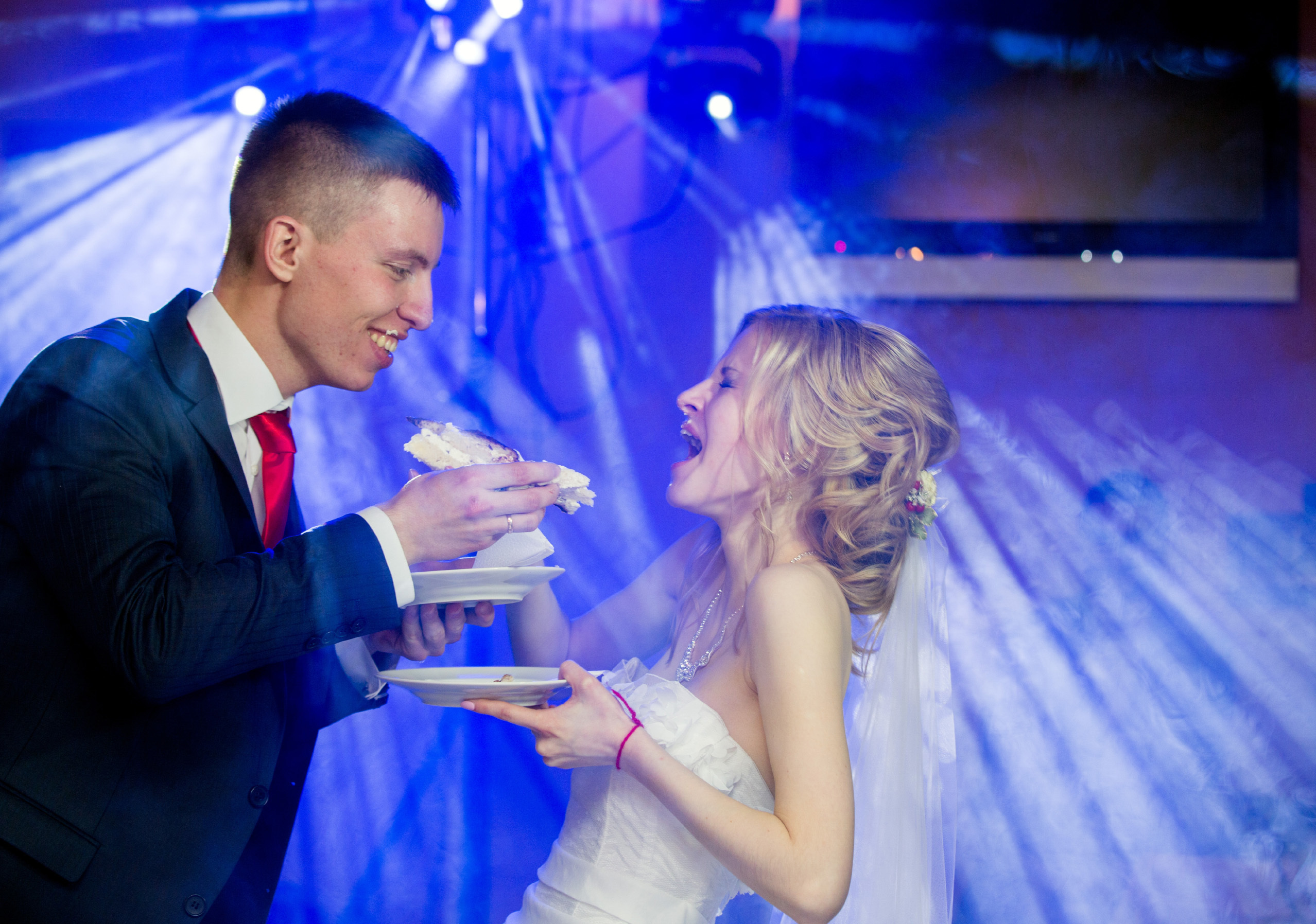 жених с невестой угощают друг друга тортом.