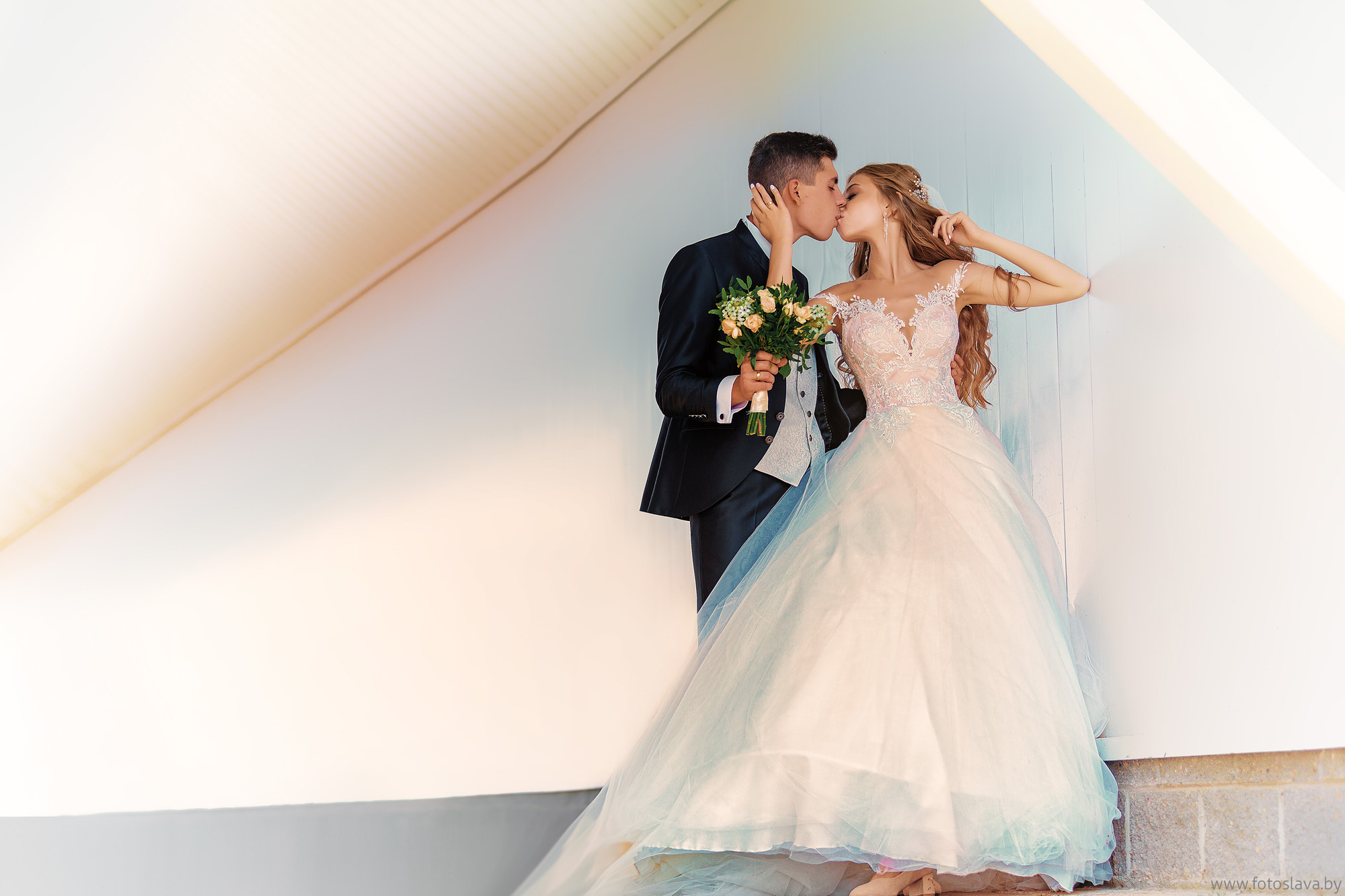 жених и невеста в полный рост красиво обнимаются на красивом фоне.