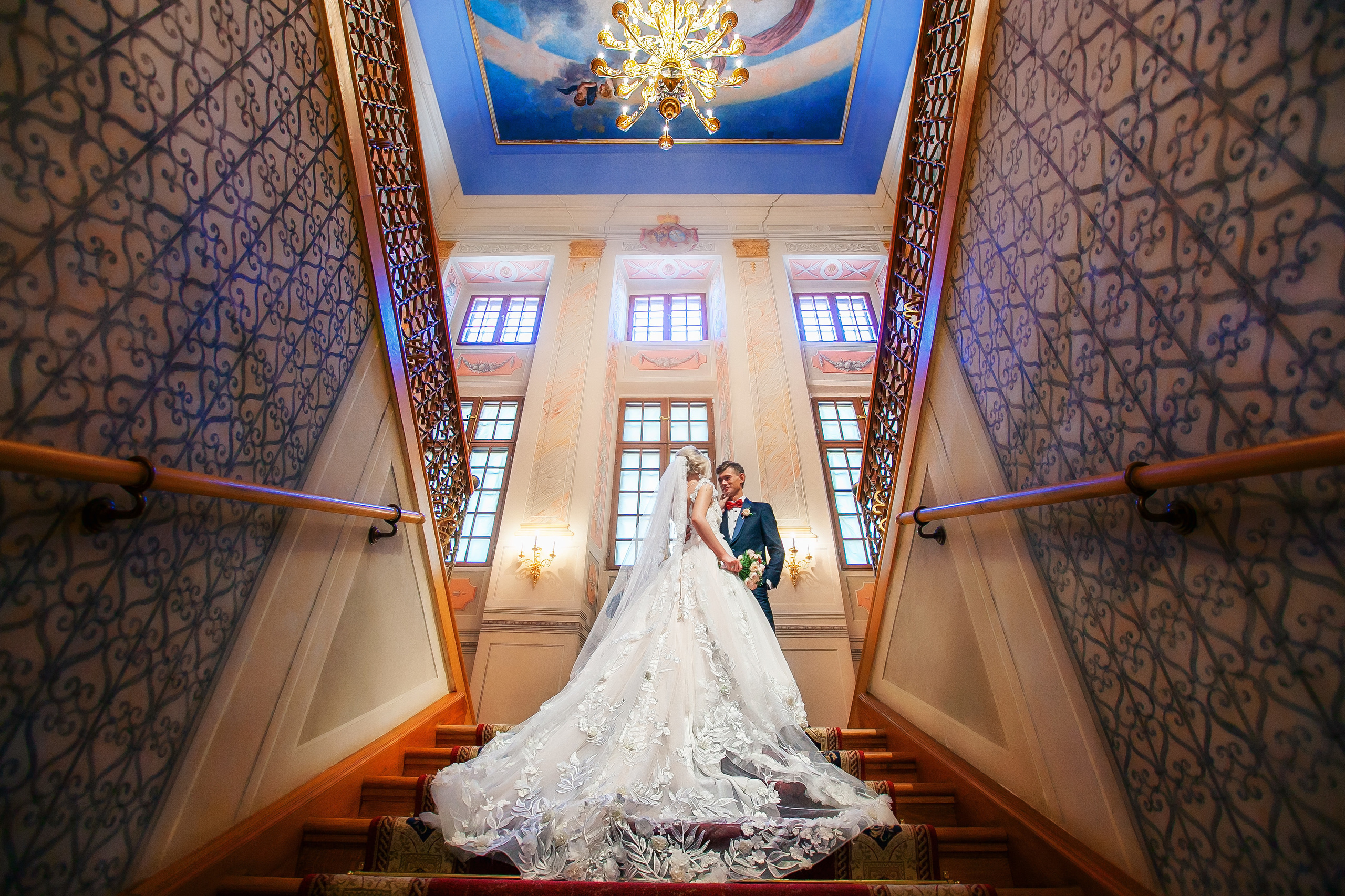 жених с невестой на лестнице замка вид снизу.