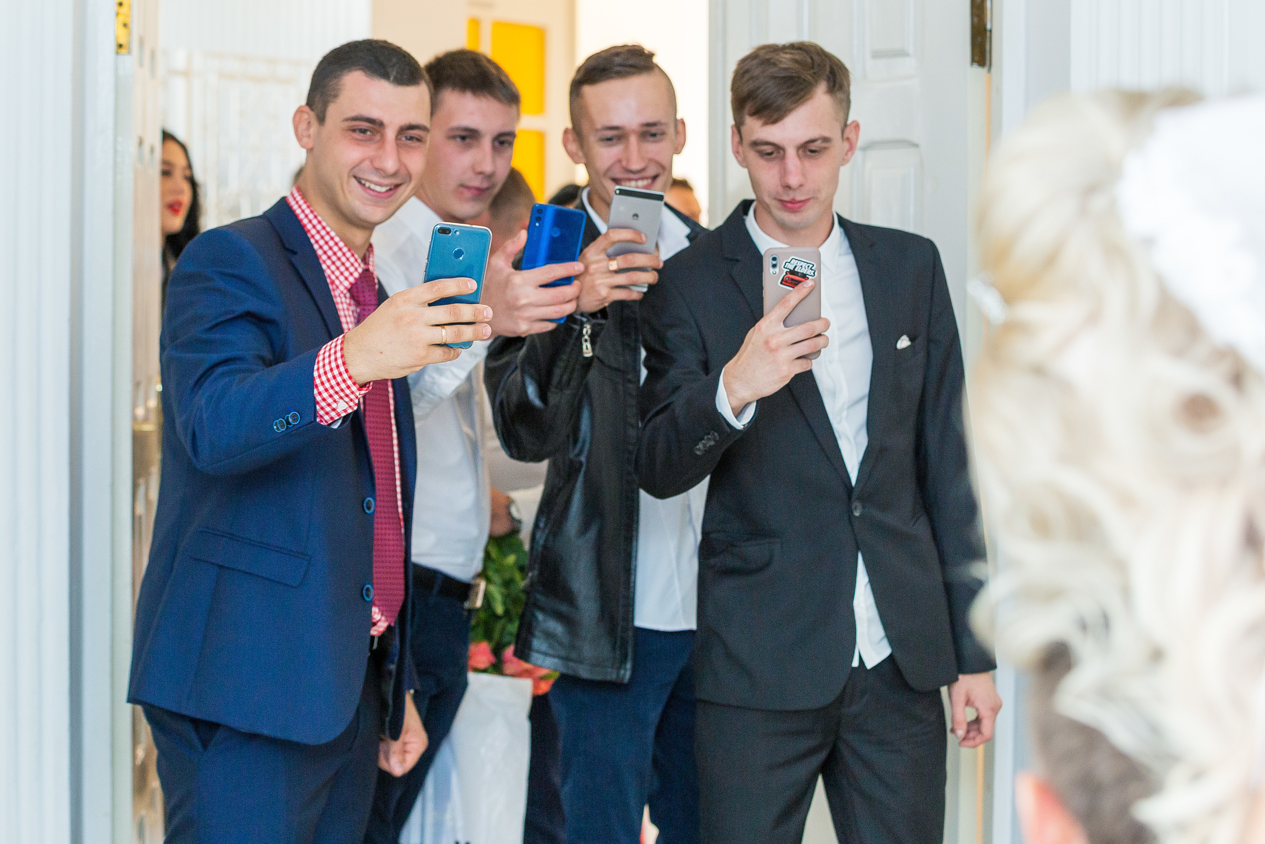 друзья молодожен снимают их на смартфоны.