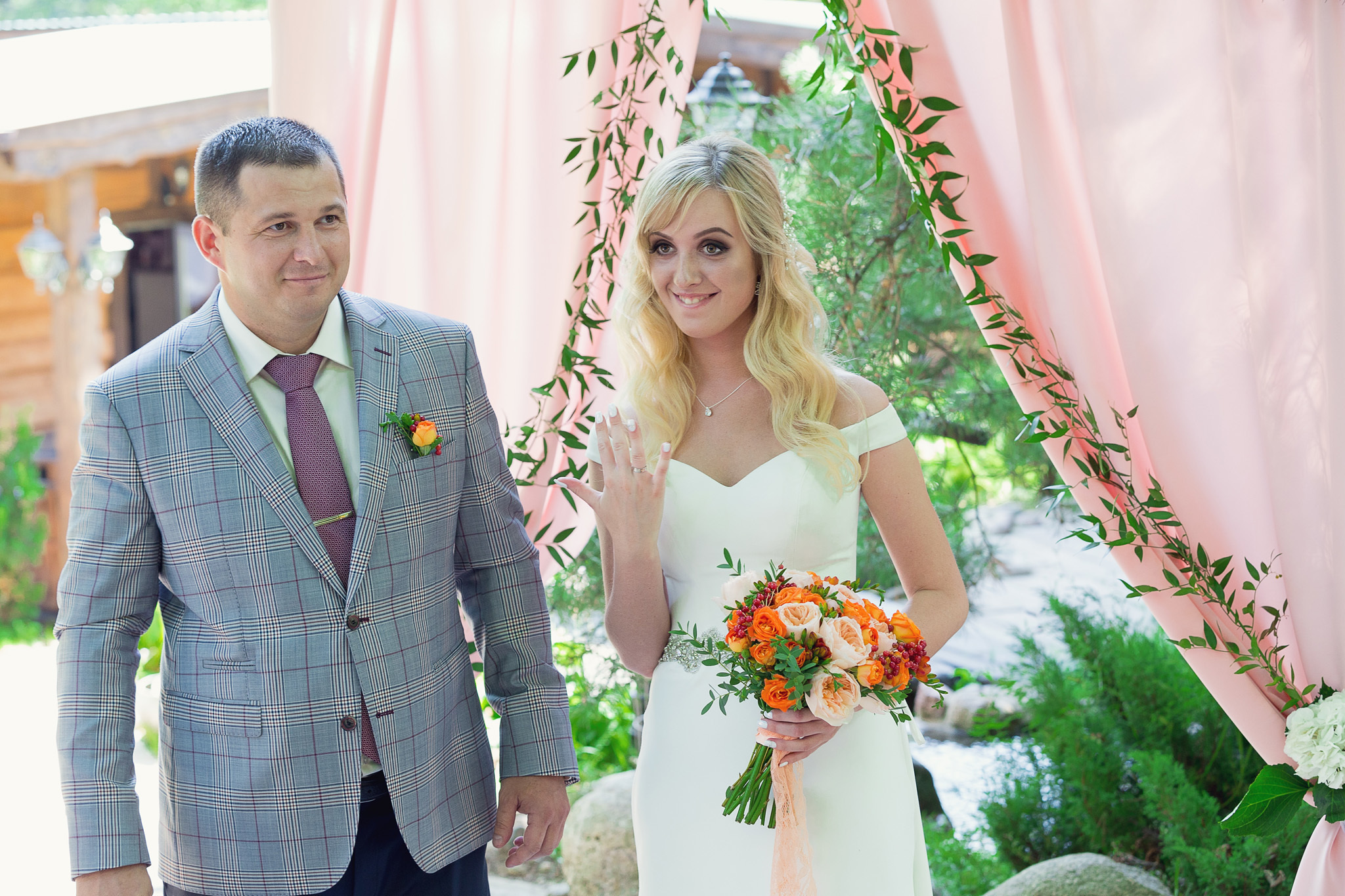 невеста показывает палец с кольцом.