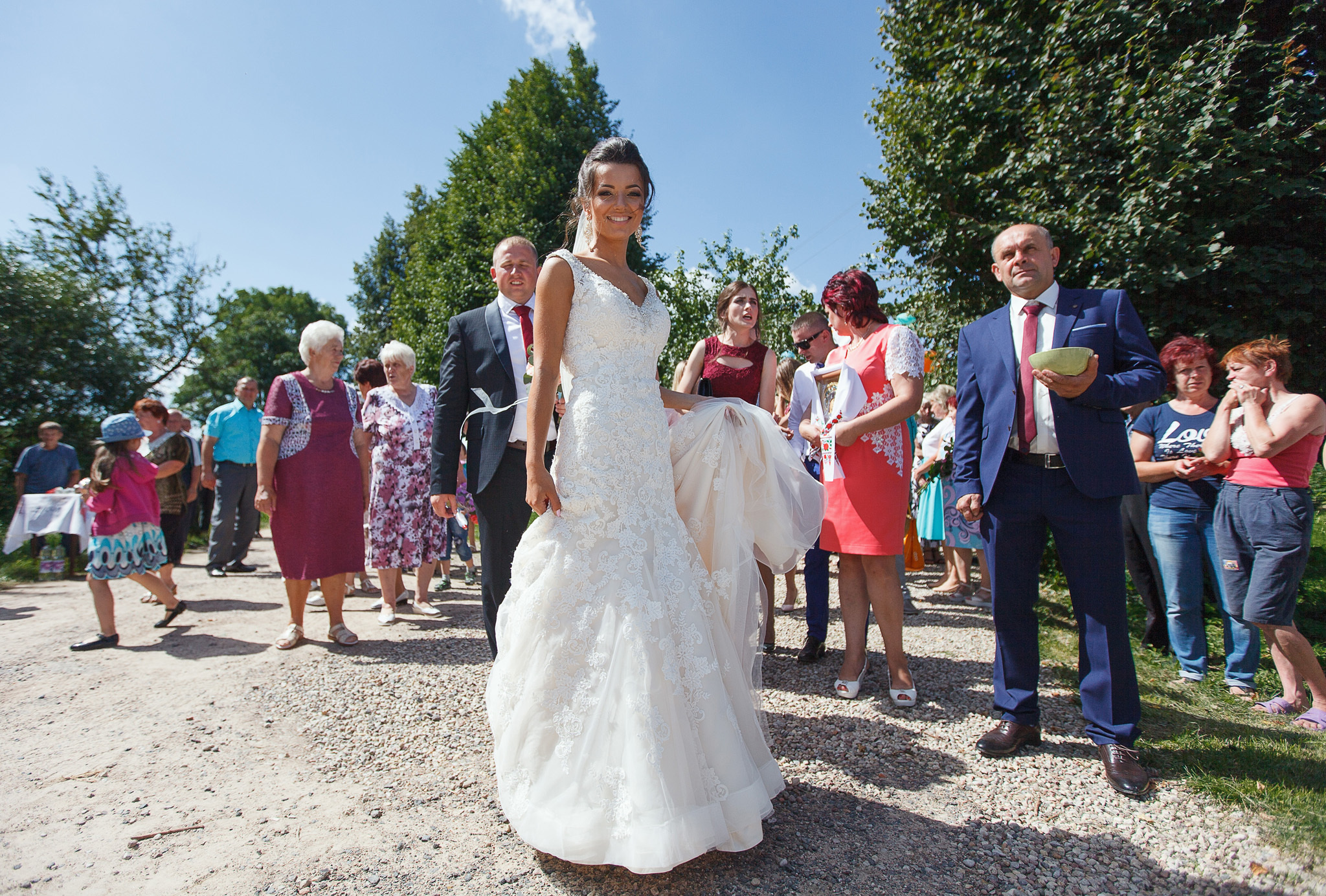 портрет невесты в полный рост на фоне гостей.