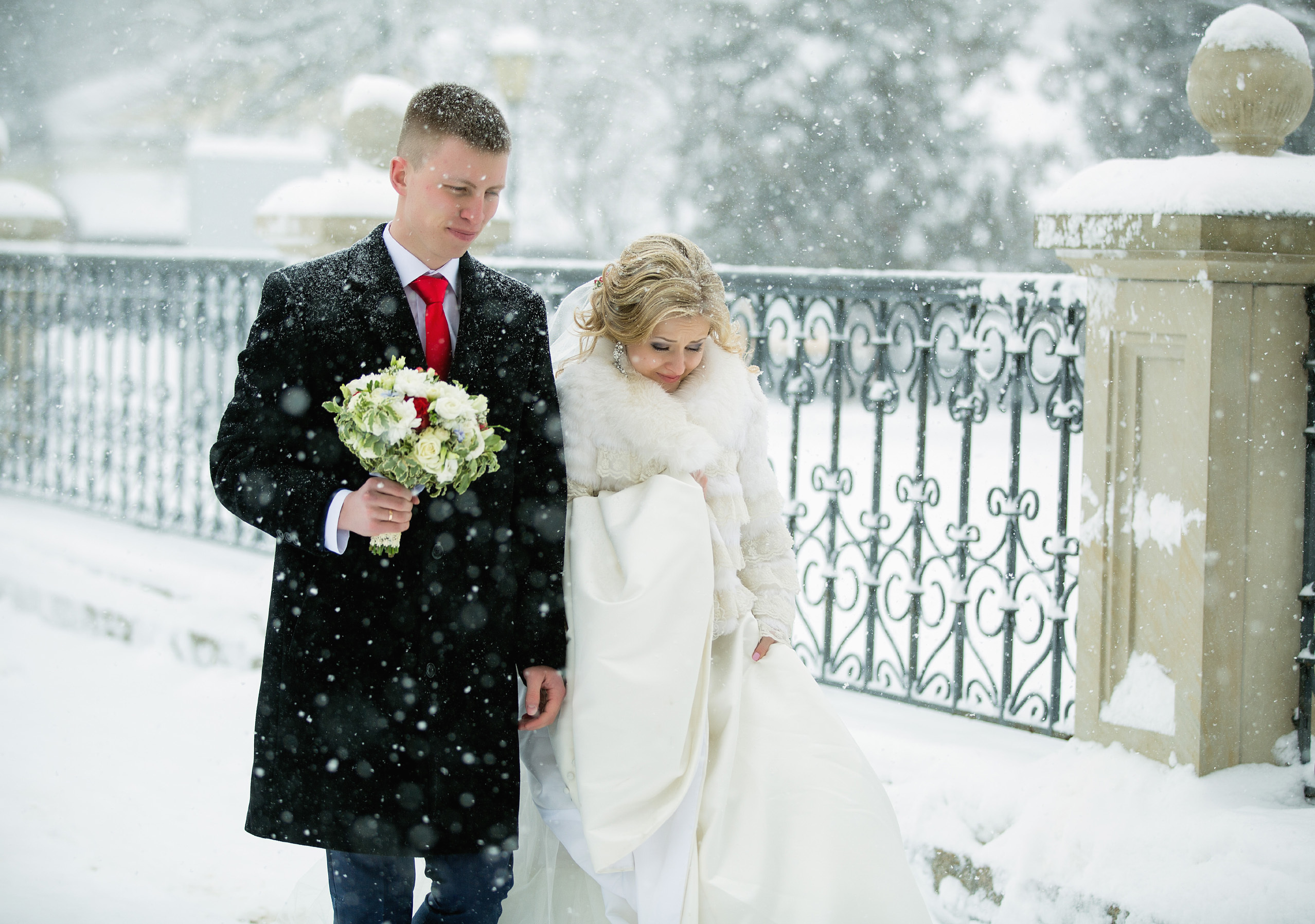 жених с невестой идут по зимней улице.
