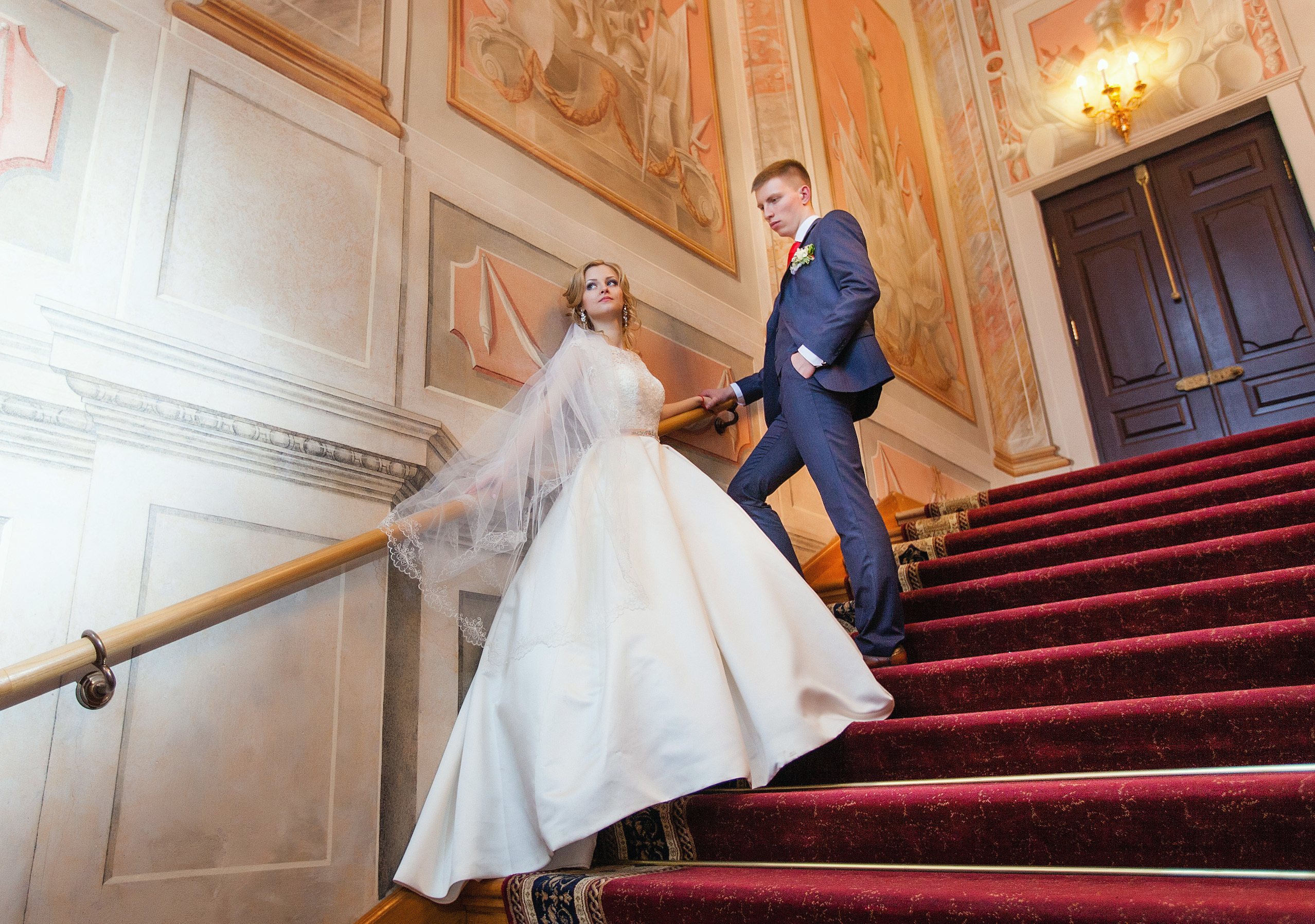 невеста с женихом стоят на лестнице.