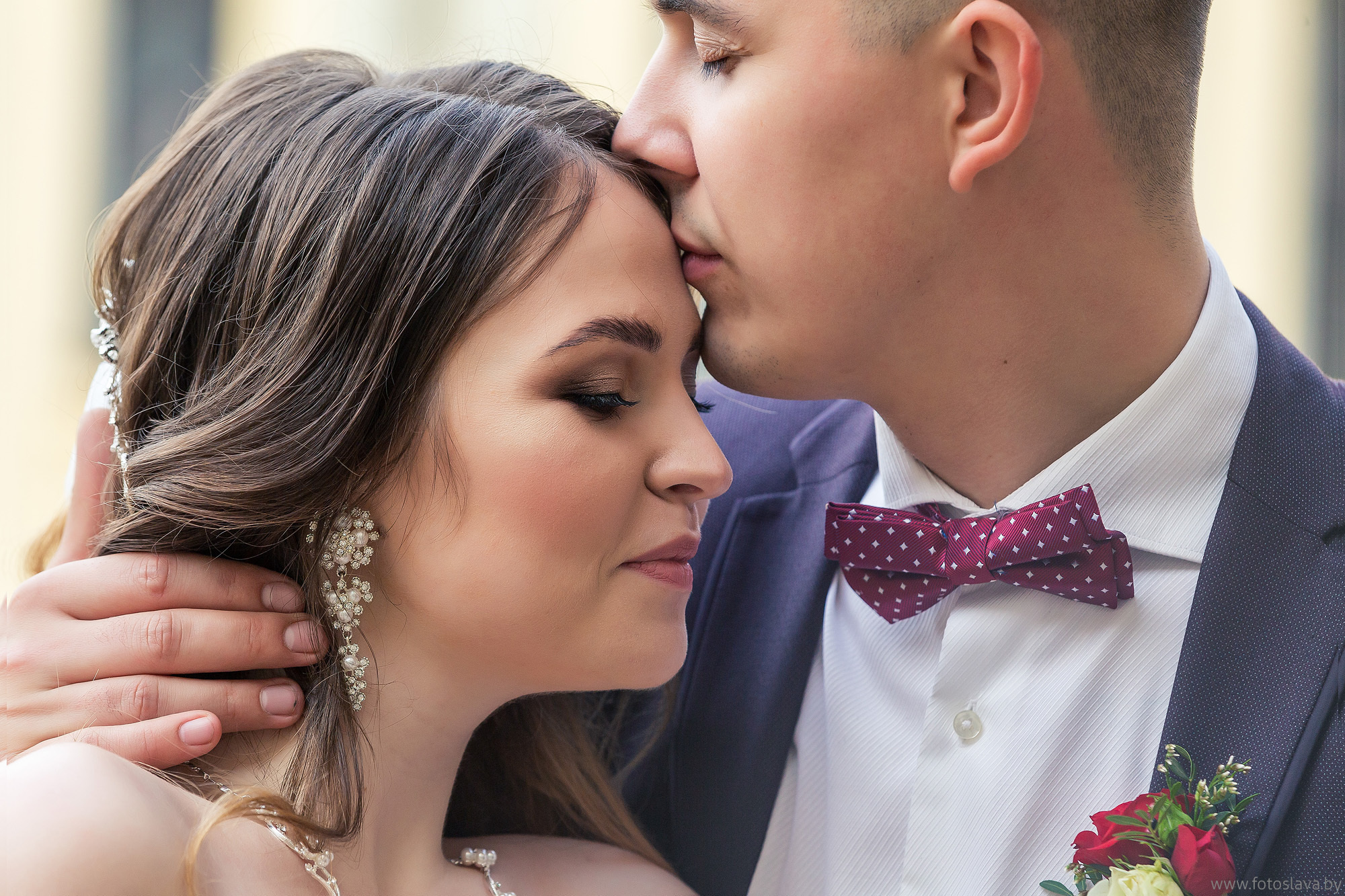 жених целует невесту в лоб, снято крупно.