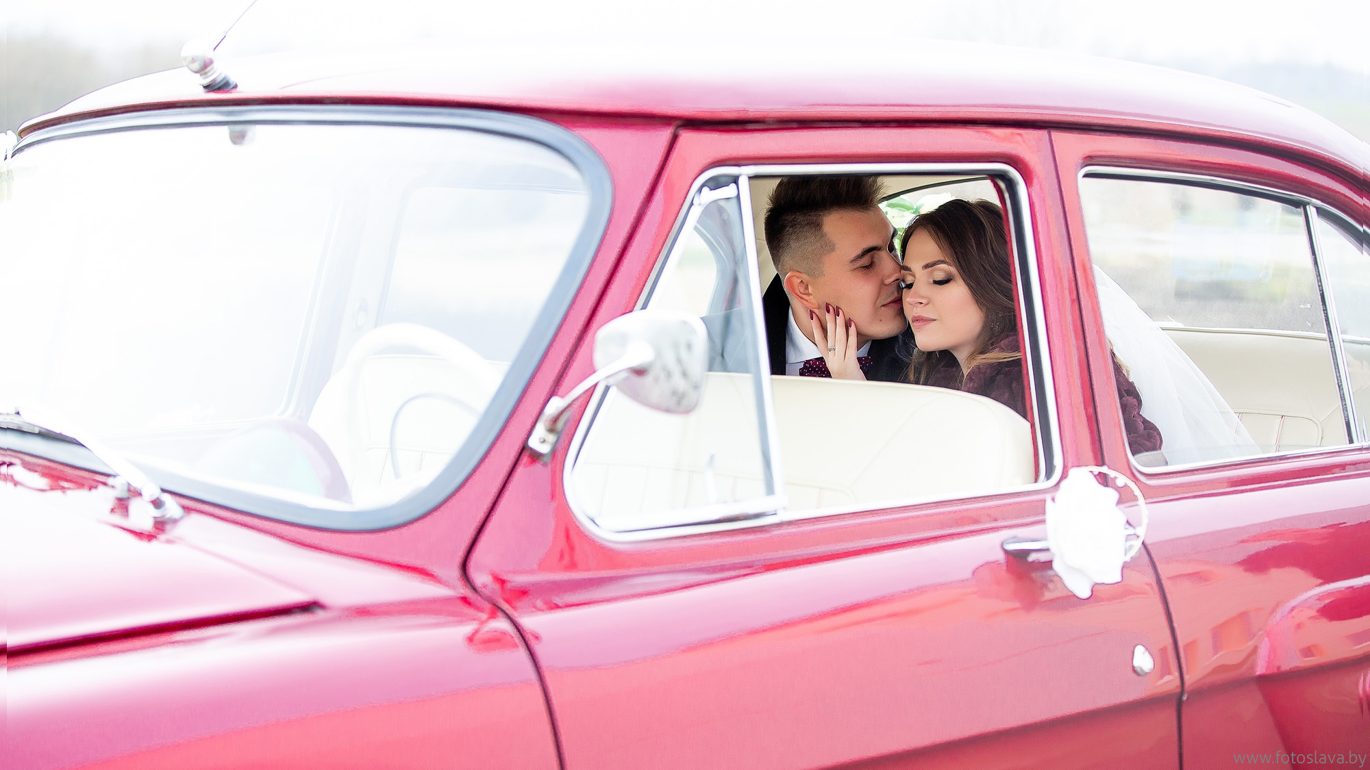 молодые целуются в ретро авто на заднем сиденье, снято с улицы.