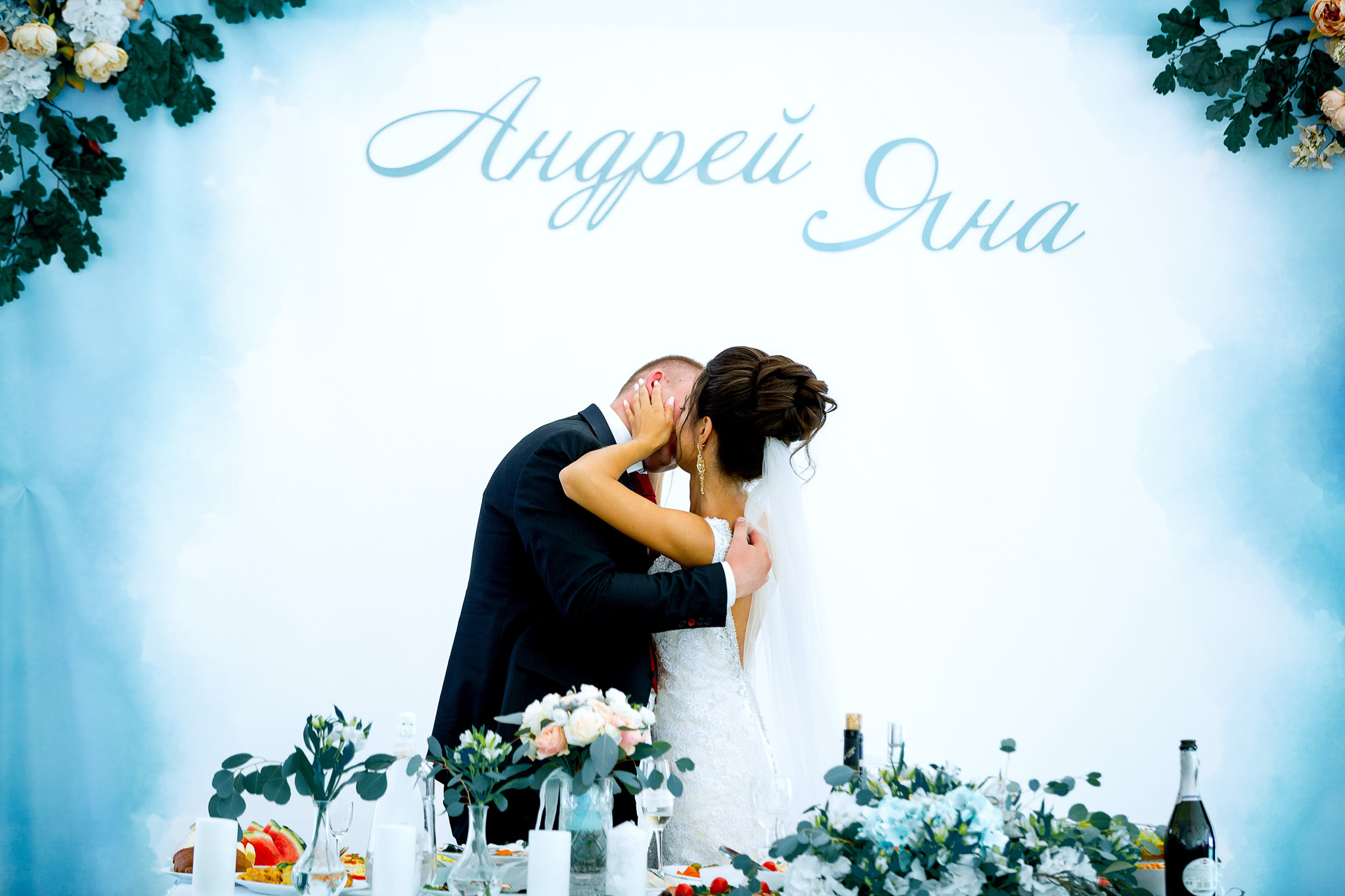 жених с невестой в страстном поцелуе на голубом фоне.