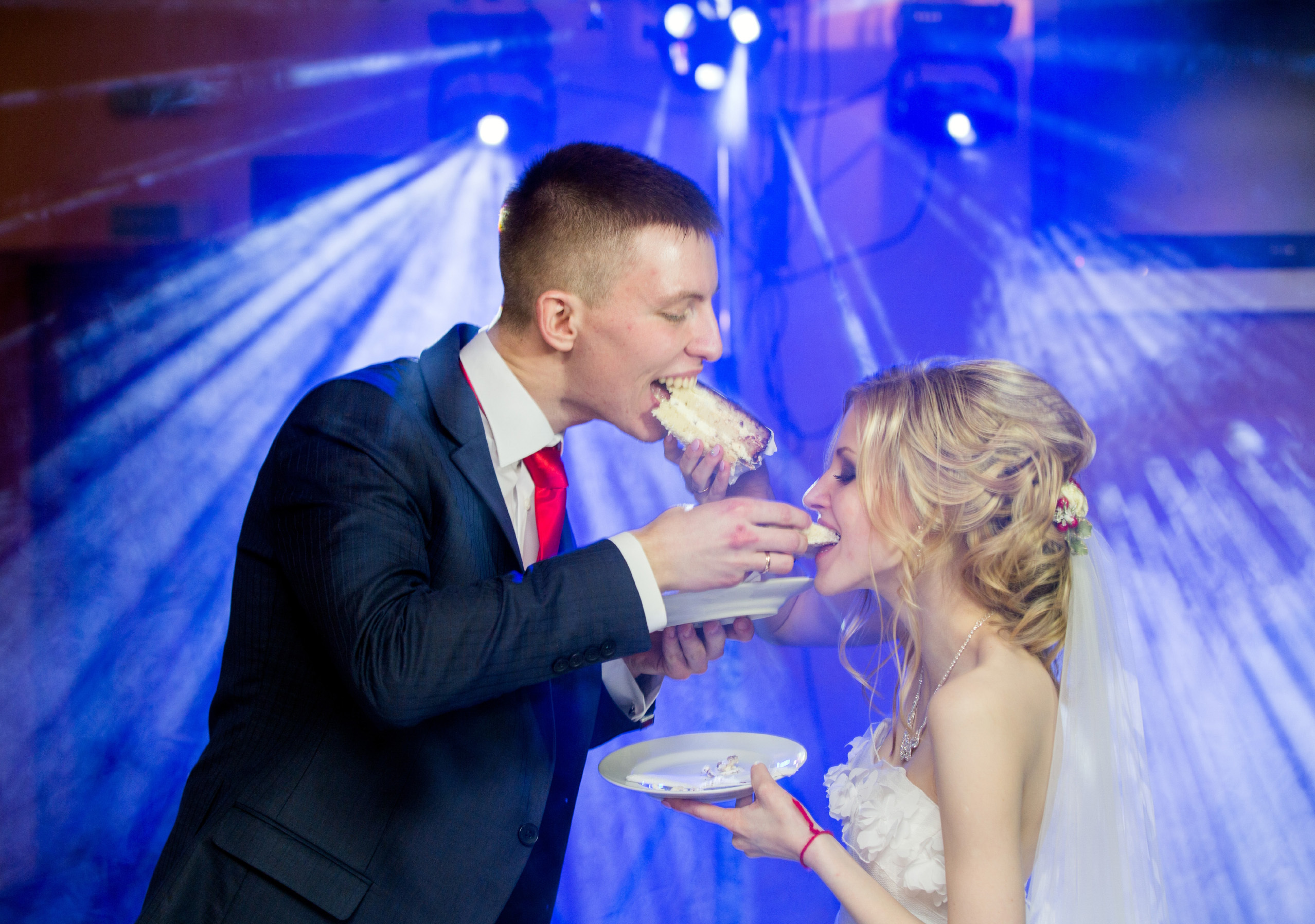 жених с невестой угощают друг друга тортом.