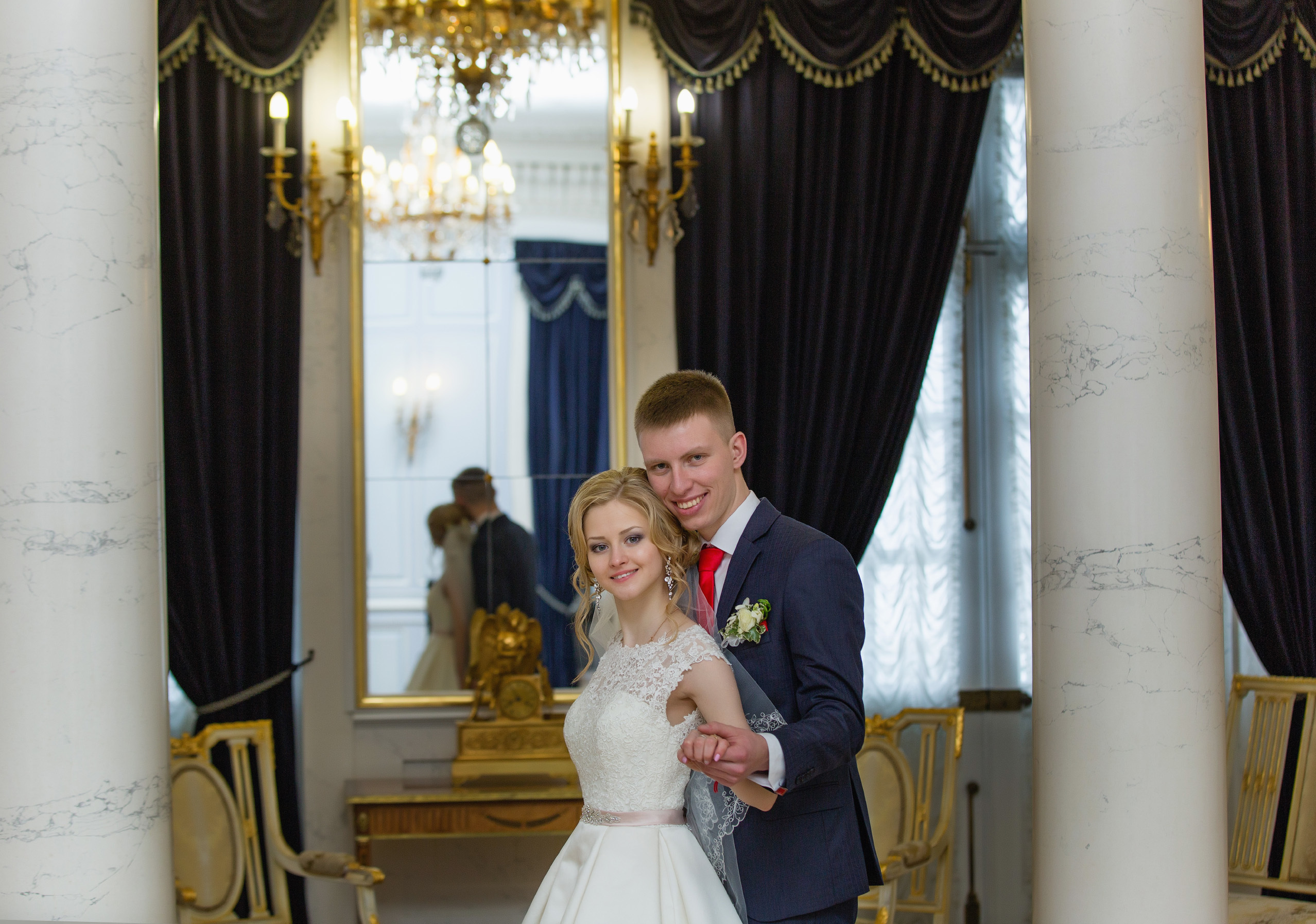 жених обнимает невесту сзади и смотрят на вас.