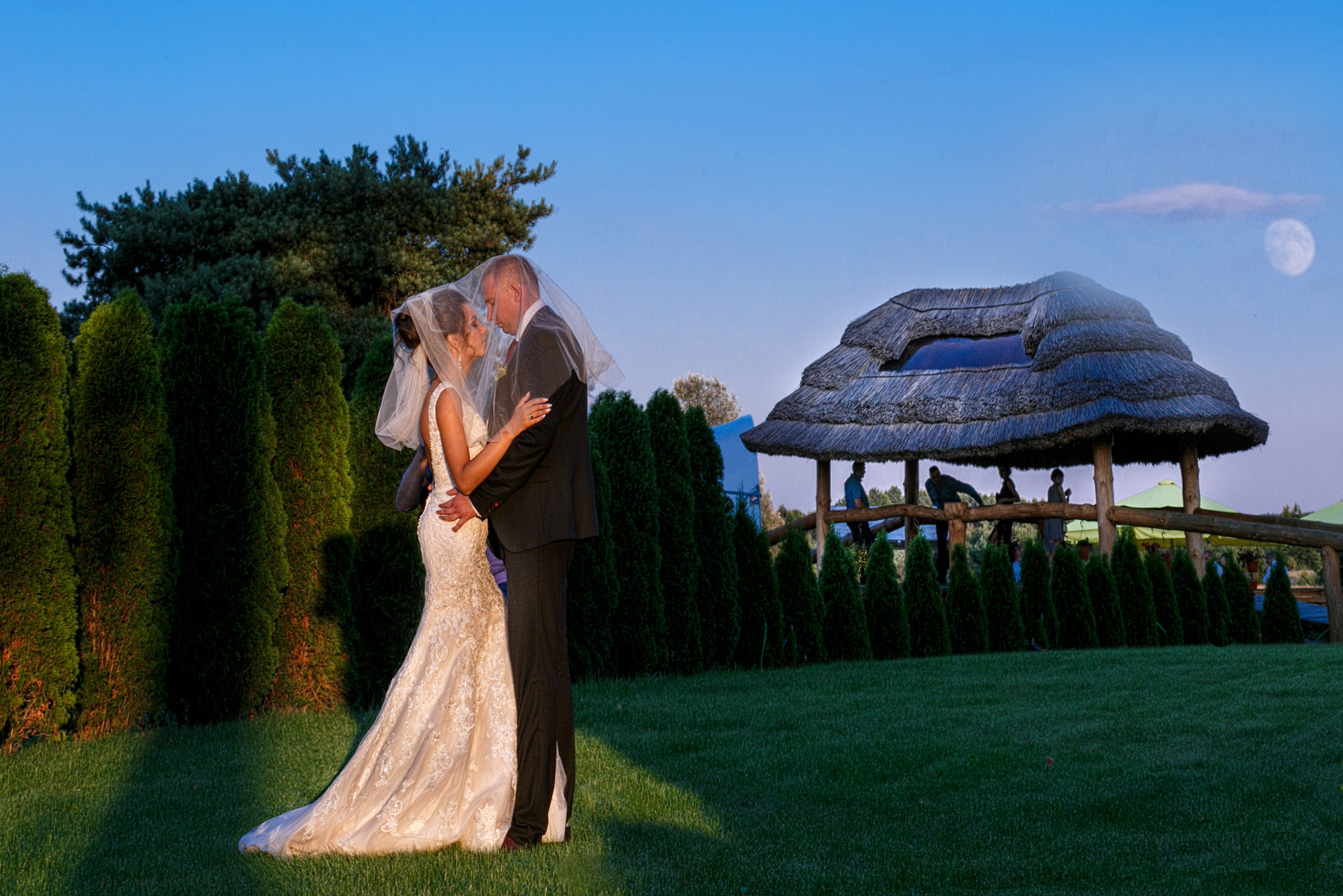 жених с невестой обнимаются в лучах закатного солнца.