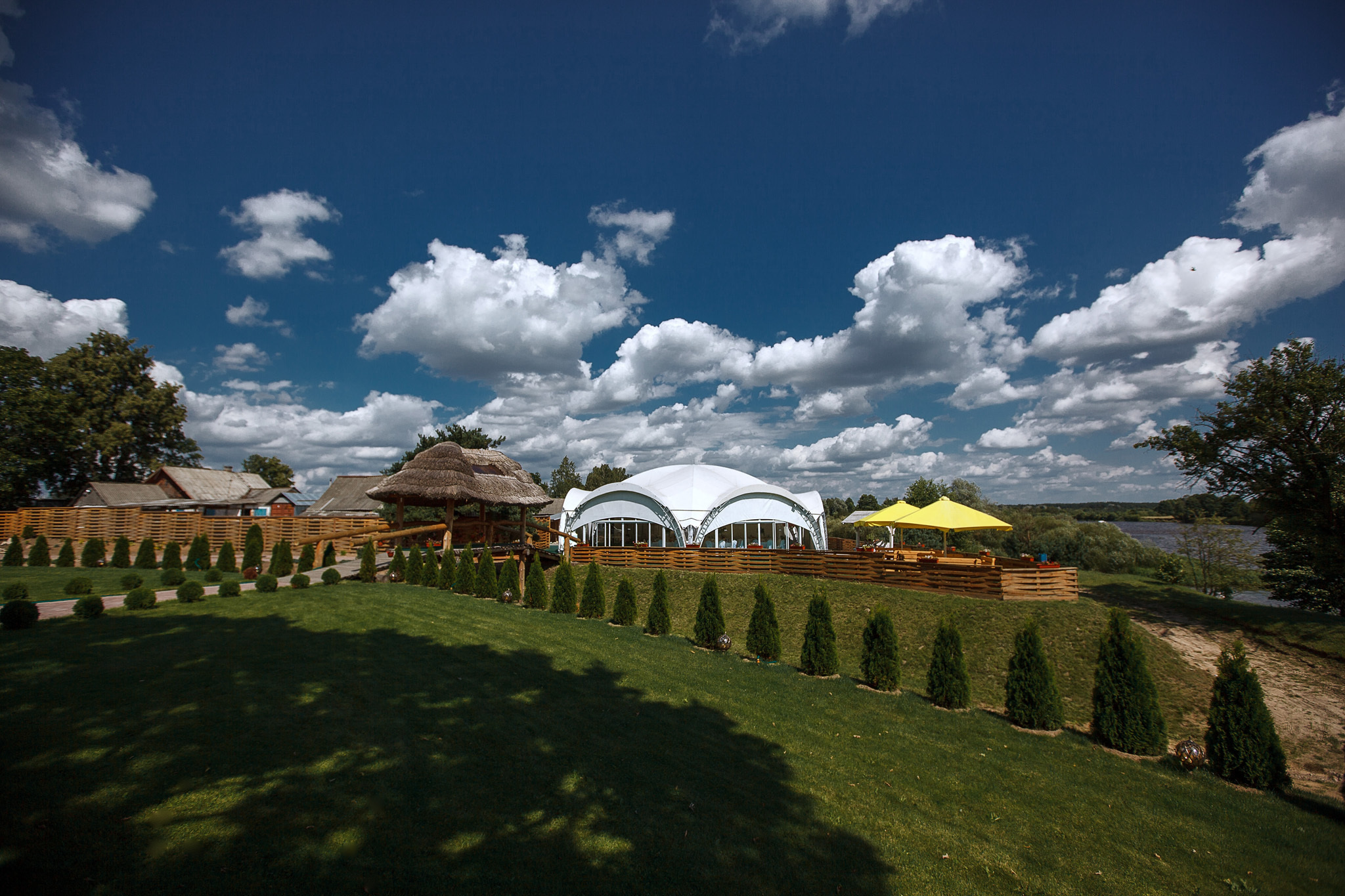 свадебный шатер на лужайке на фоне красивого неба.