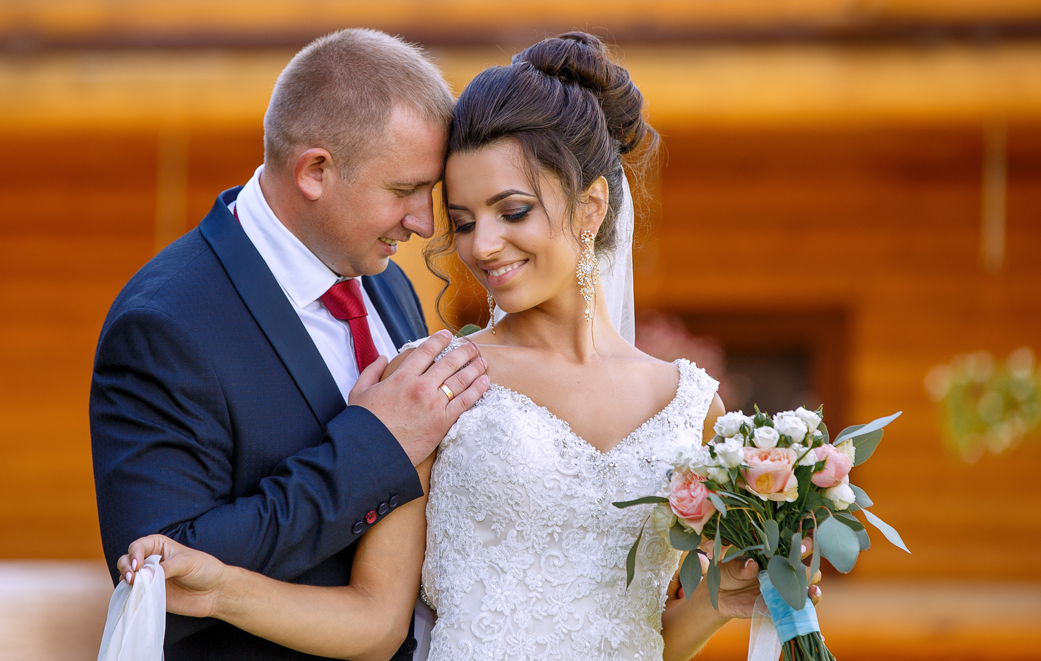 жених сзади нежно обнимает невесту, соприкоснувшись головами.