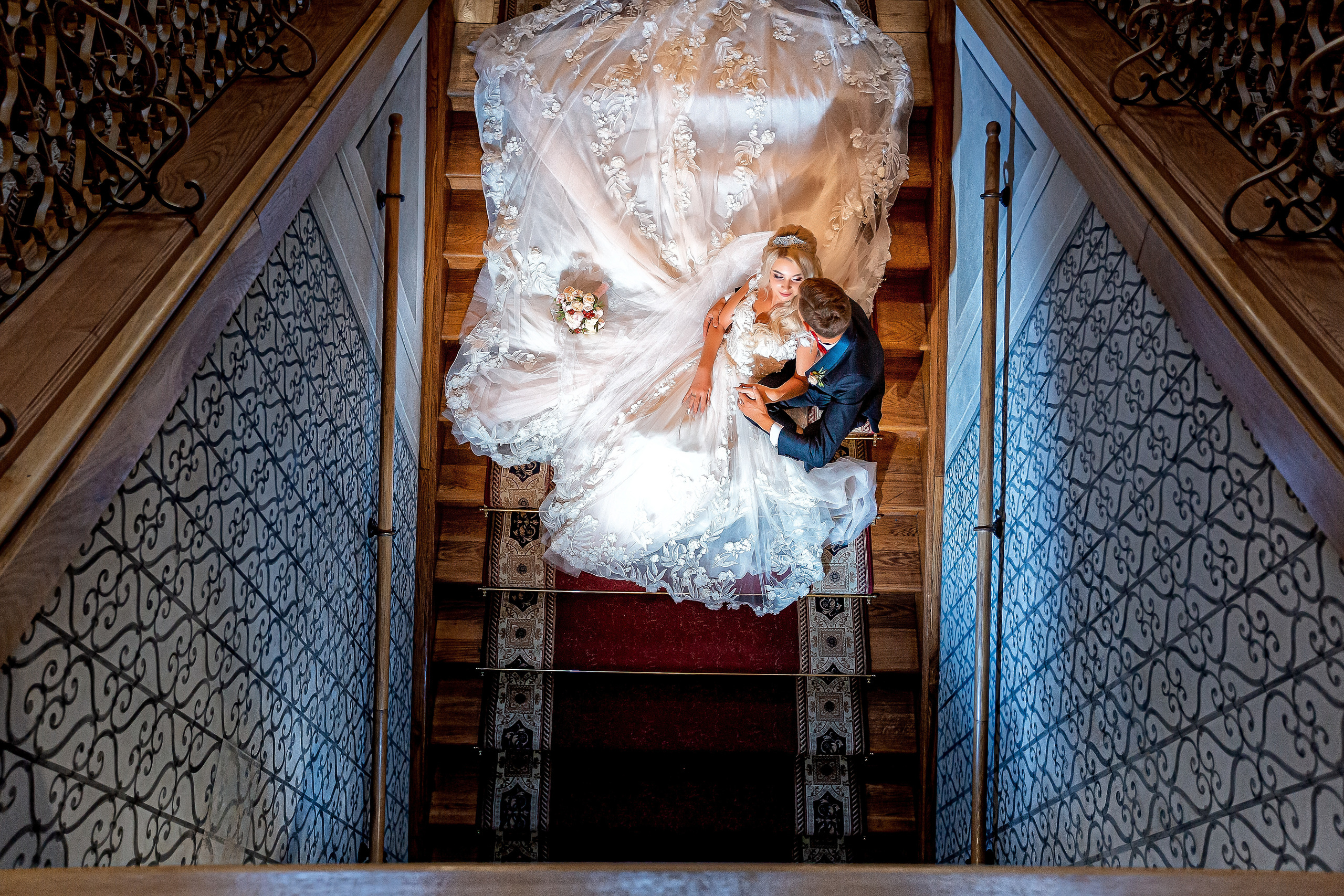 жених с невестой сидят на лестнице в обнимку вид сверху.