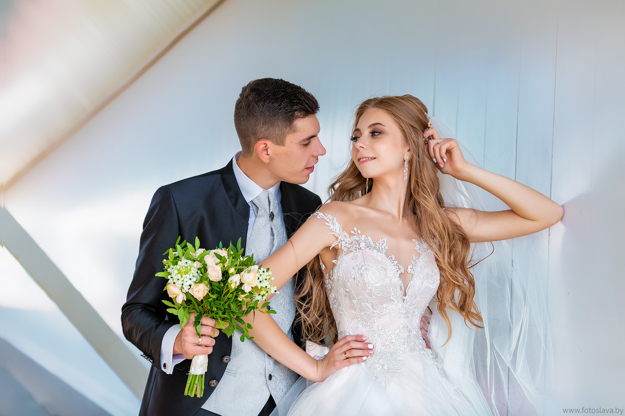 жених с невестой с любовью смотрят друг на друга на красивом синем фоне.