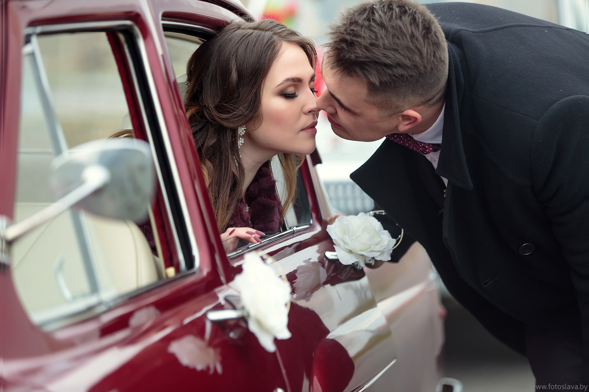 невеста в машине жених с наружи целует ее.