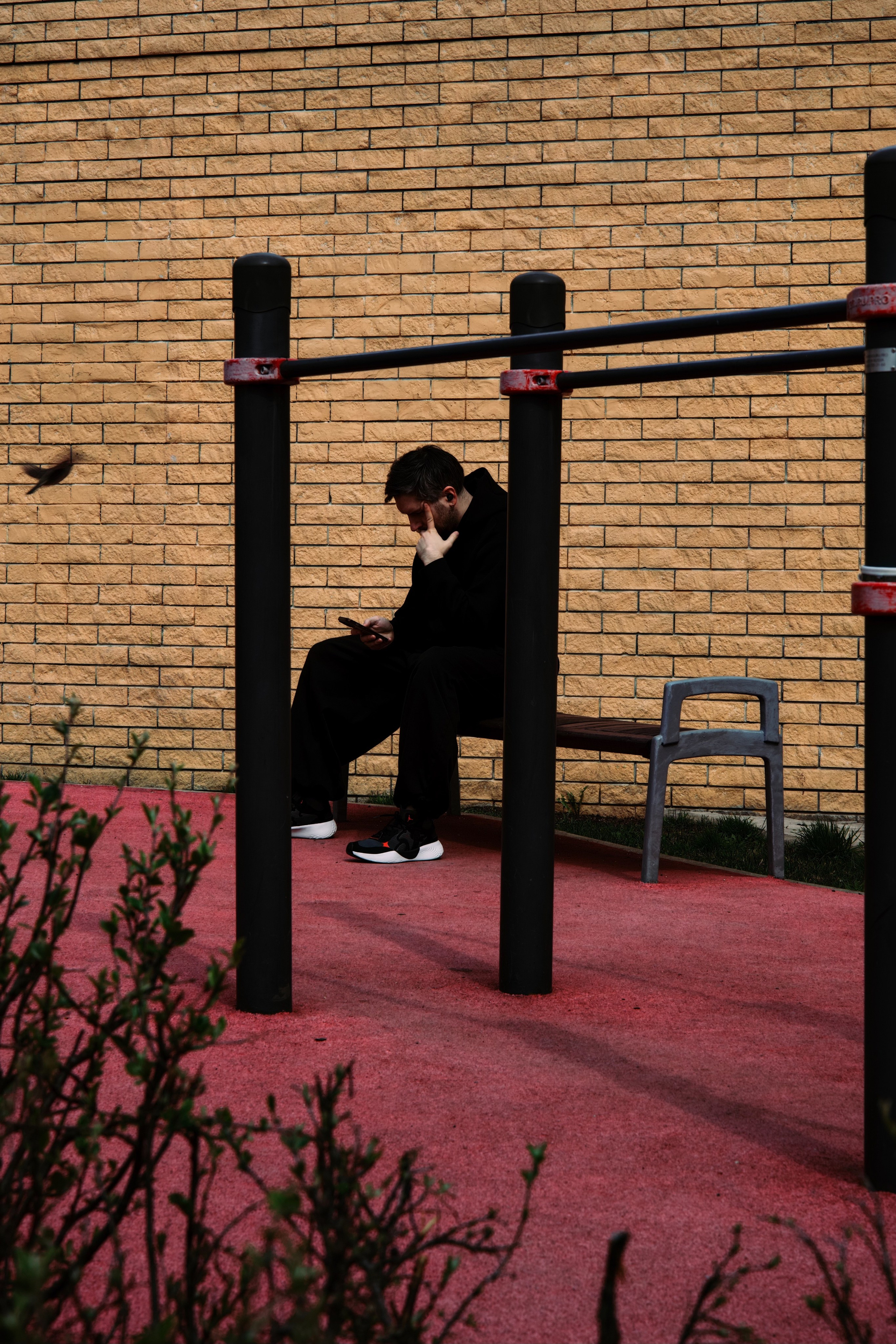 человек сидит на лавочке в парке на розовом настиле