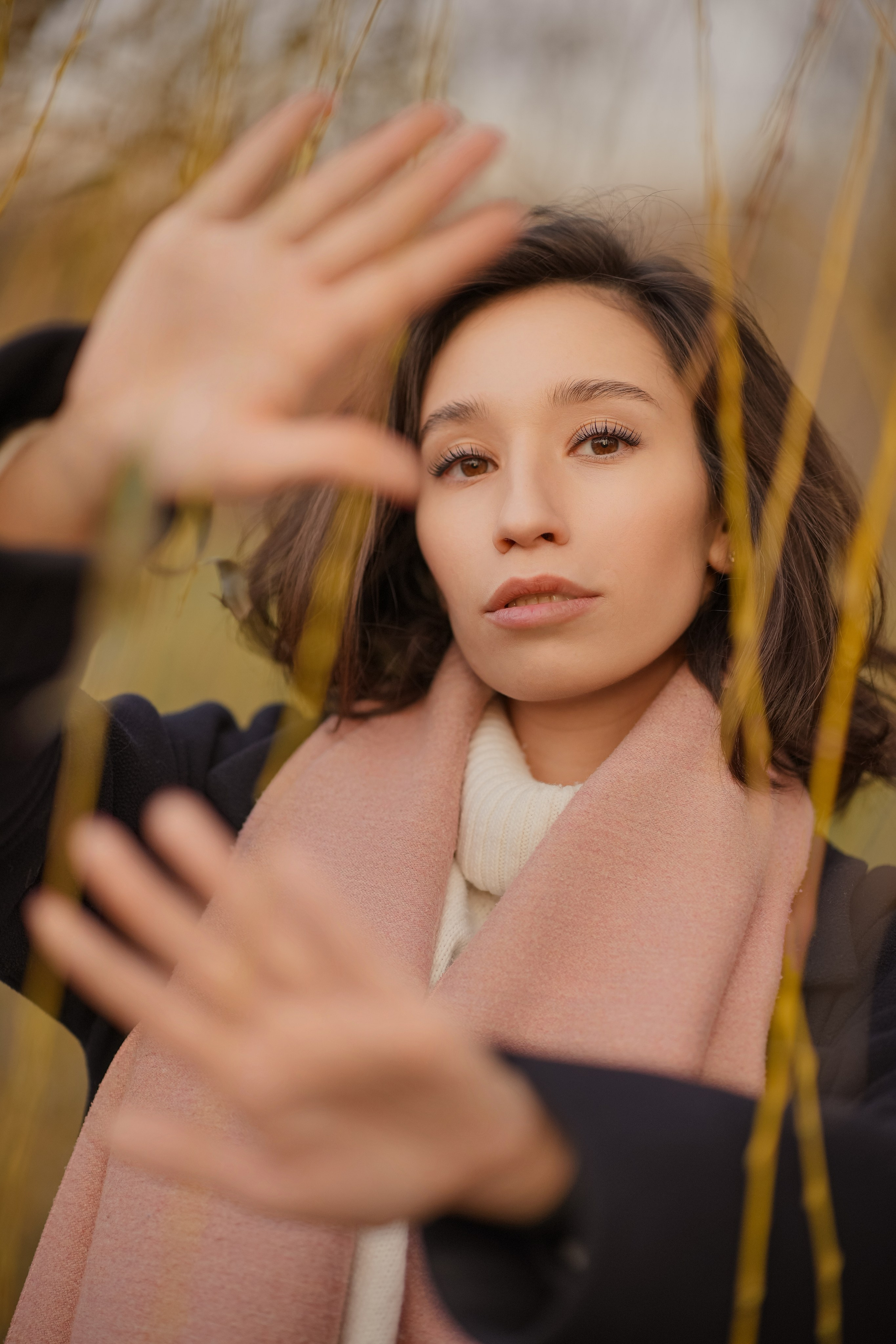 крупный портрет молодой девушки с руками в камеру в парке осенью