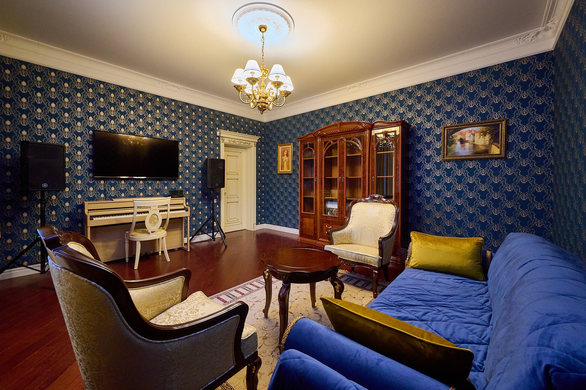 гостиная  синие обои синий диван  коричневый  столик коричневый шкаф белое кресло пианино светлое  