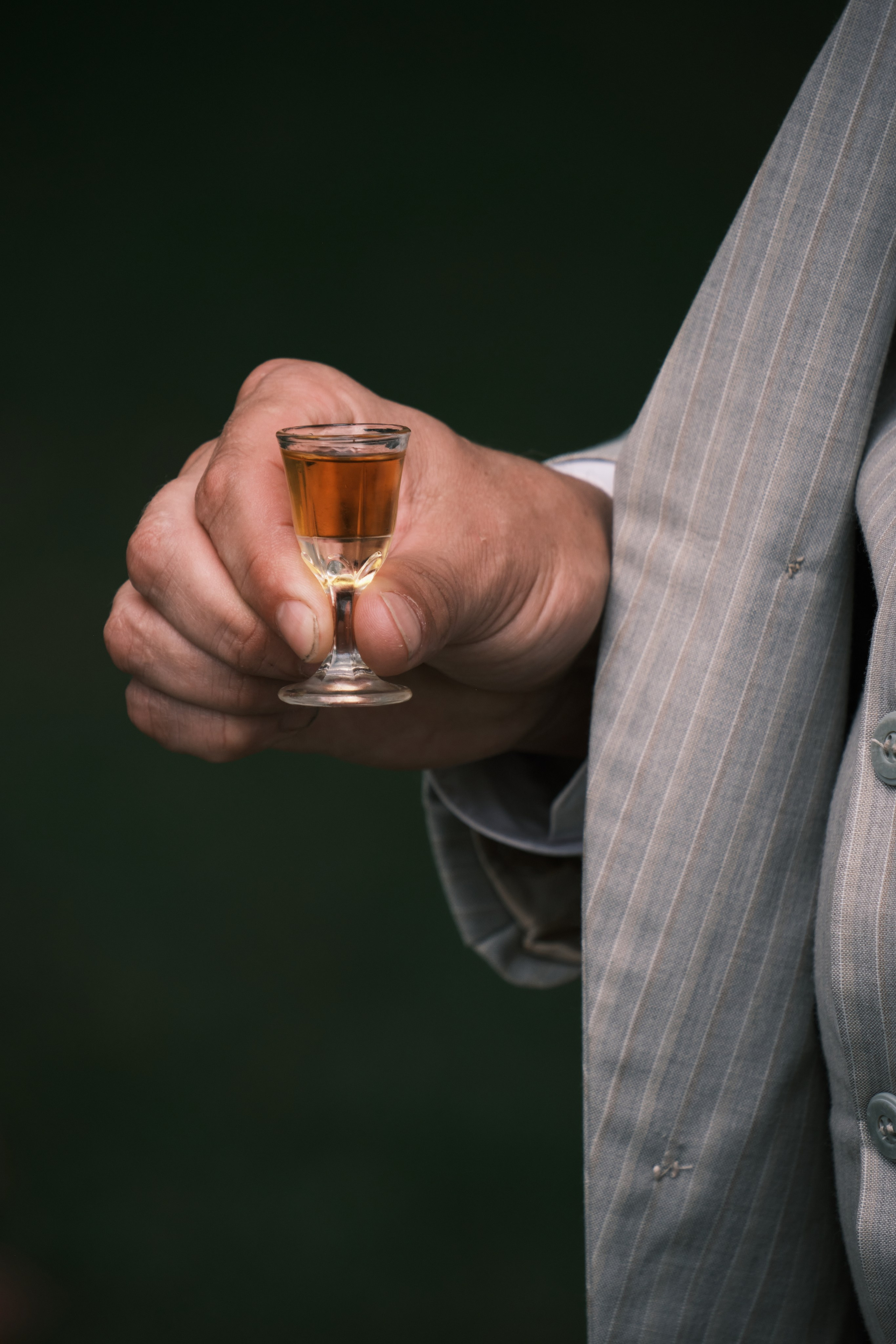 рука держит рюмку с коньяком