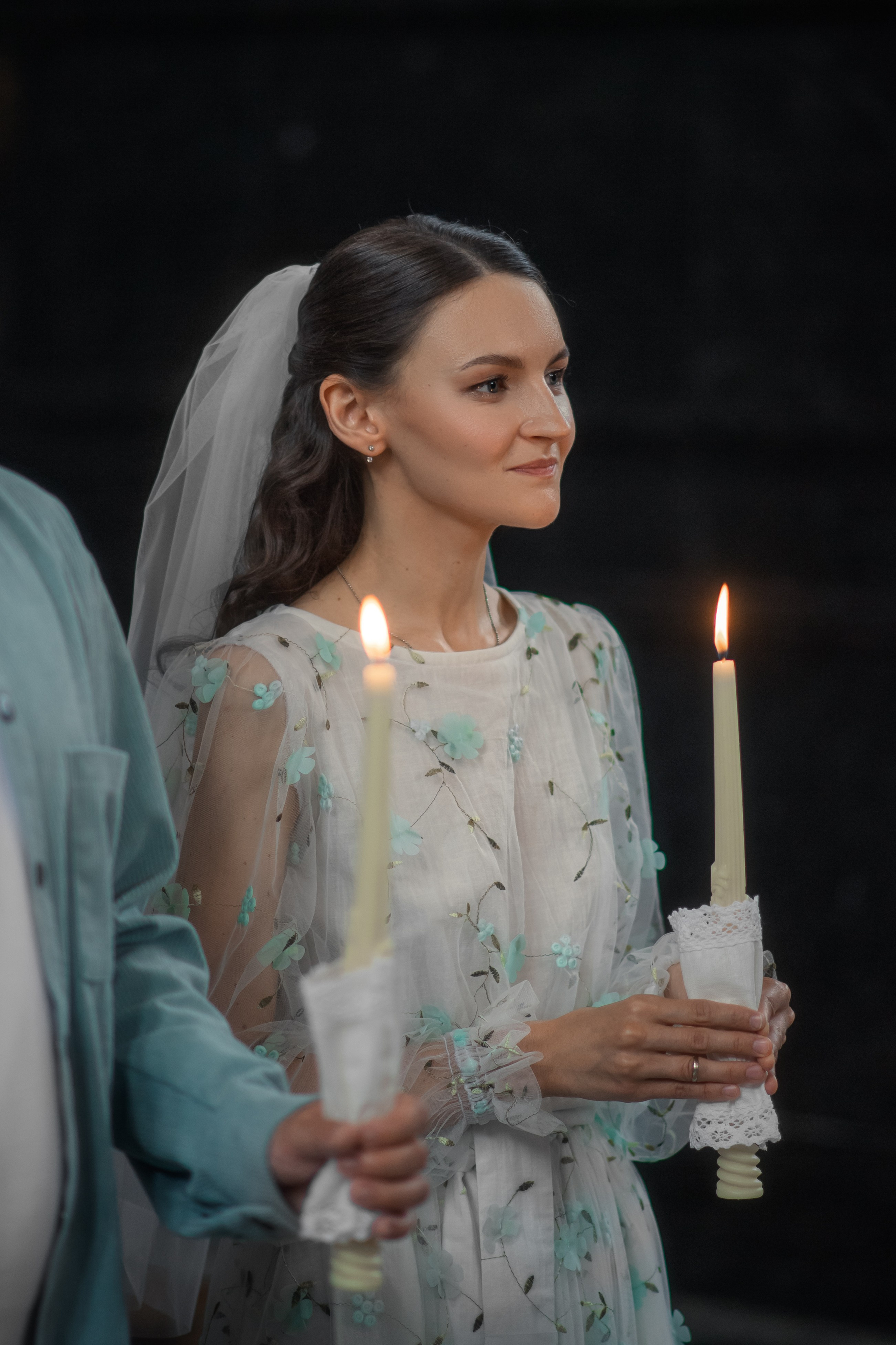 невеста улыбается со свечой в руке во время венчания в Спасе на Крови