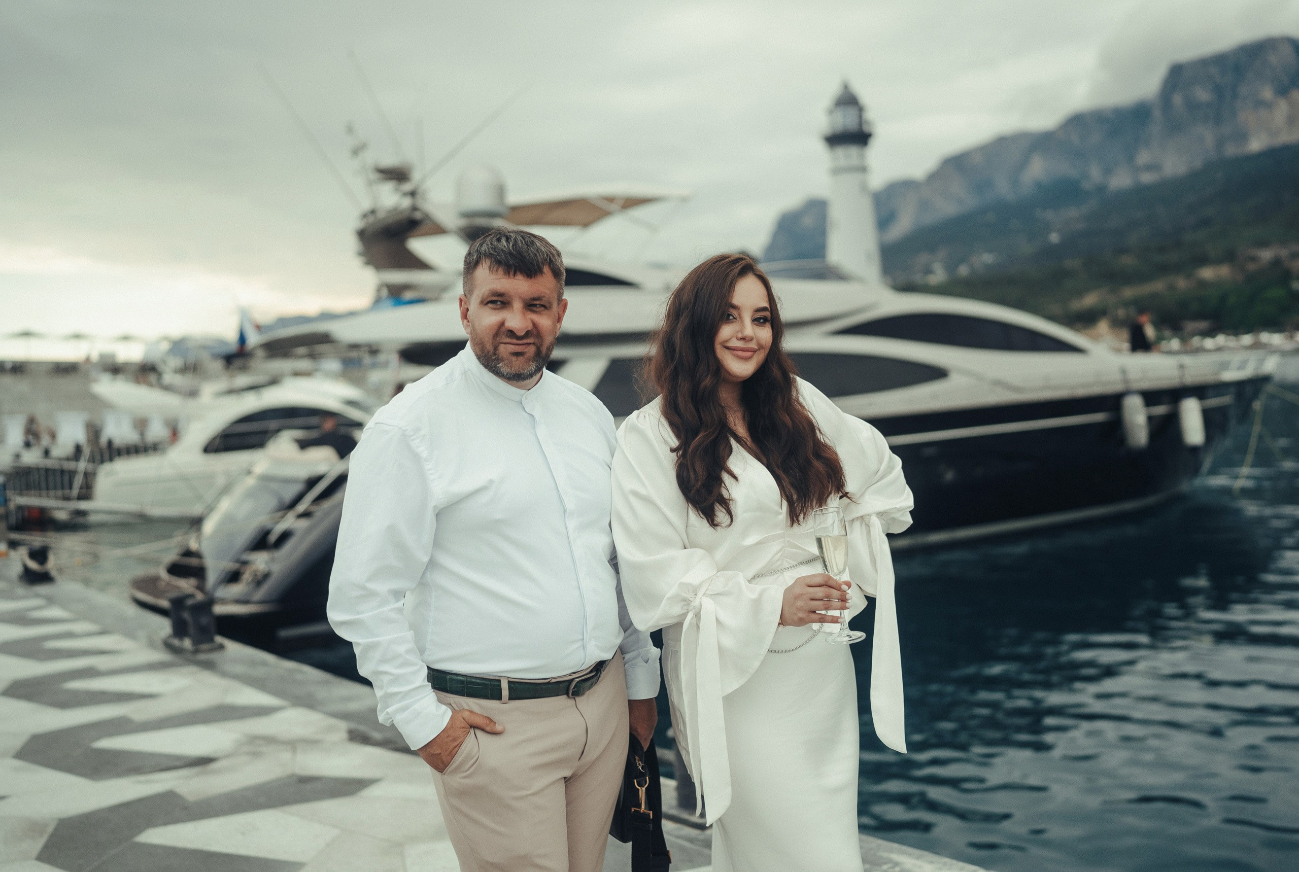 Репортажная фотосессия в Крыму: счастливые люди, мужчина и женщина, семейная пара, на прогулке на фоне яхты.
