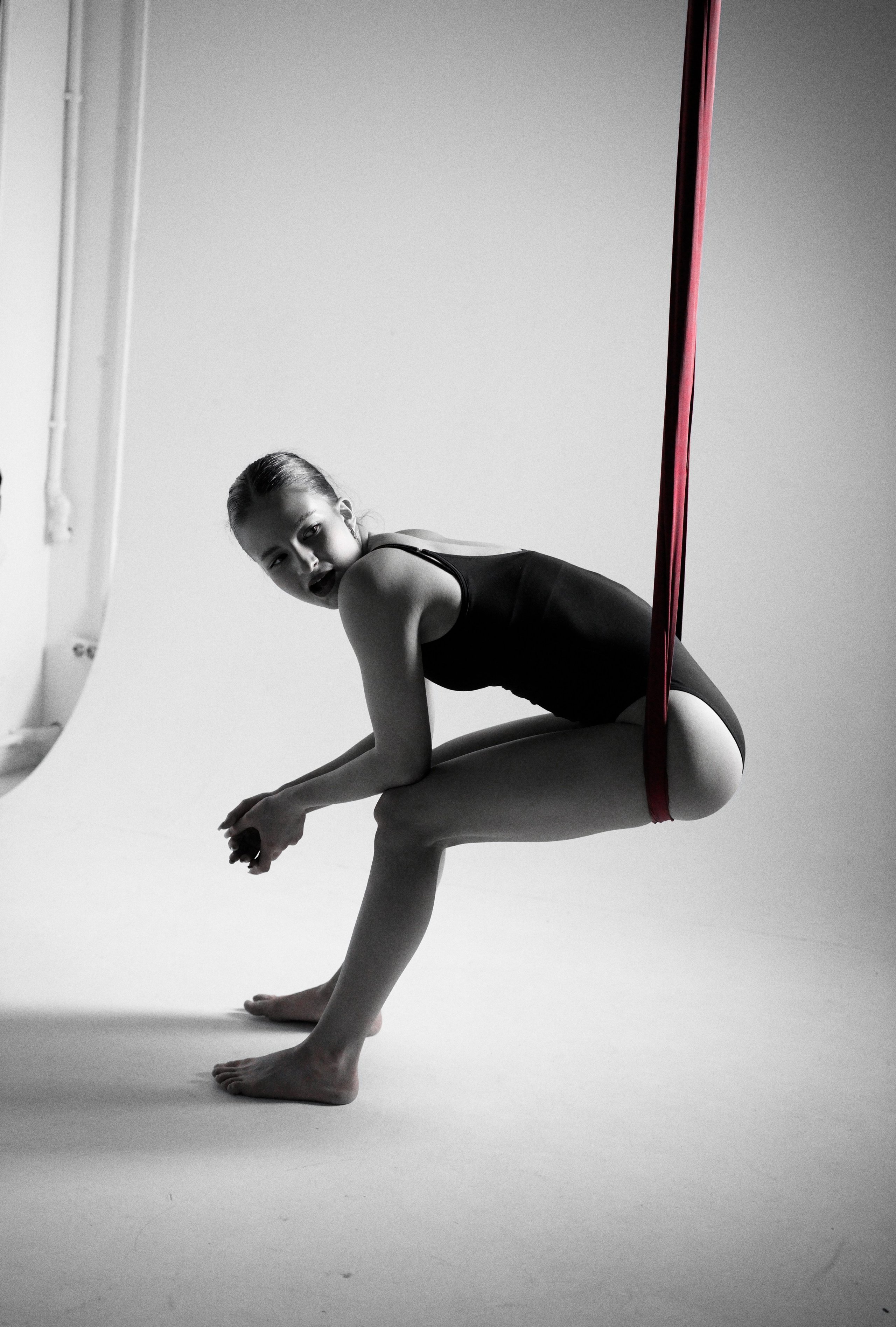 Репортажный кадр: гимнастка отдыхает в красном полотне во время съемочного процесса в Тюмени