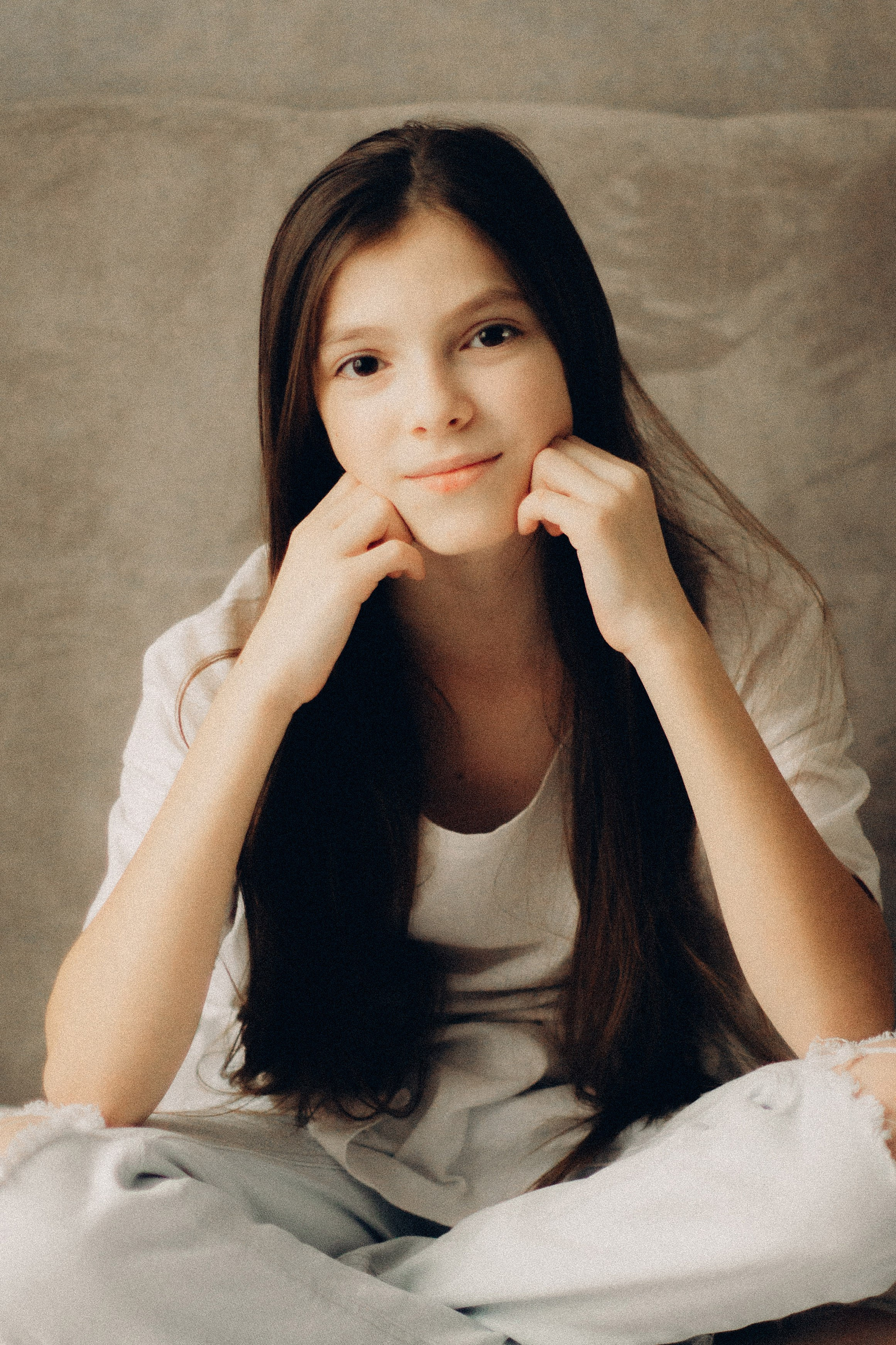 Фотосессия подростка, девочка десяти лет сидит на кровати, портрет девочки