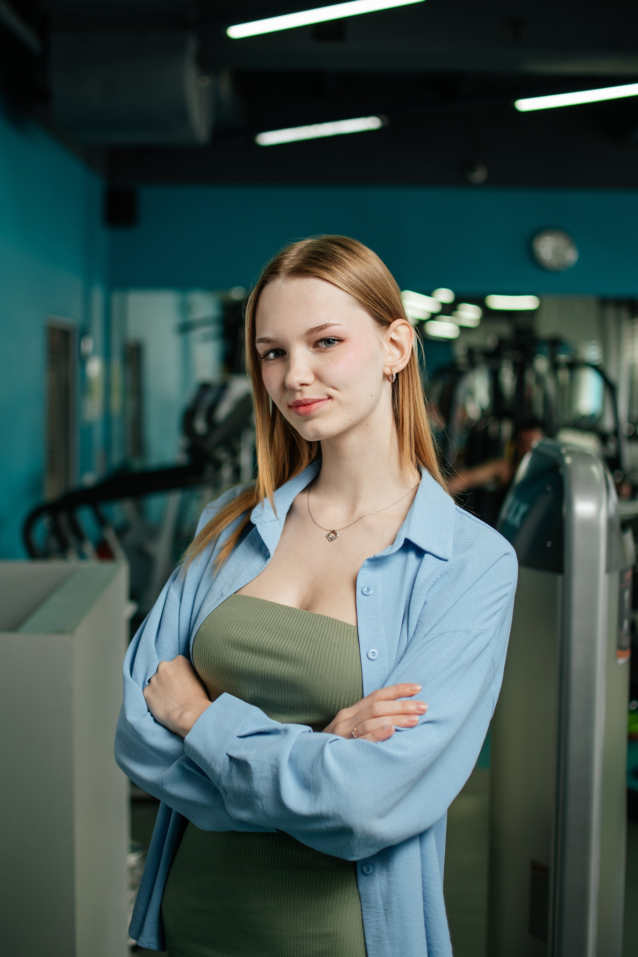 менеджер фитнес-клуба на фоне зала фитнес-клуба